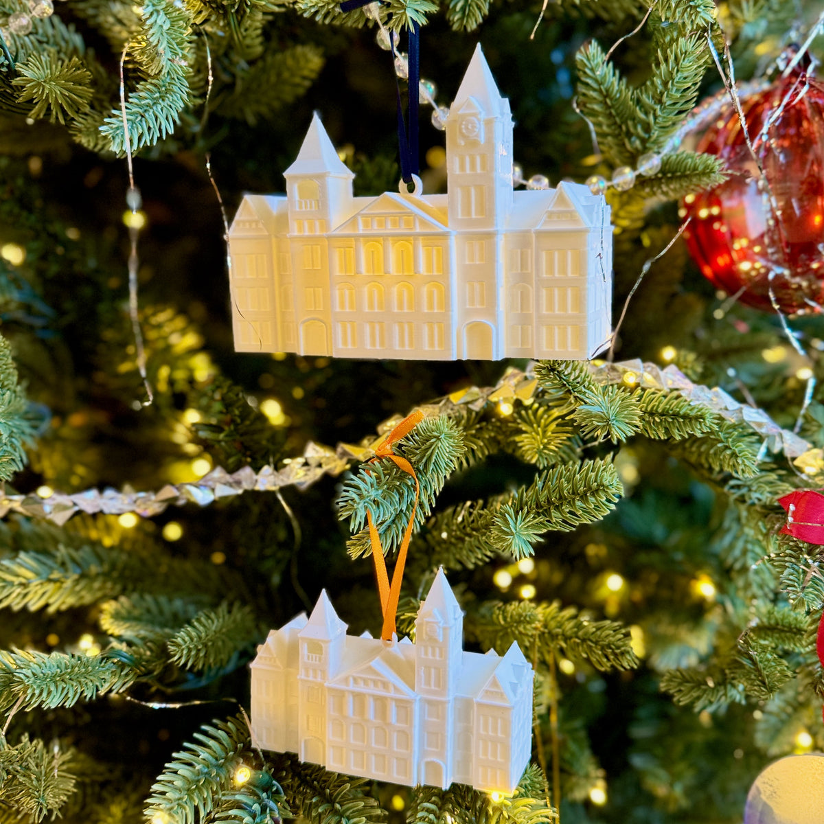 Two Auburn alumni ornaments for the Samford Hall building, shown on a Christmas tree.
