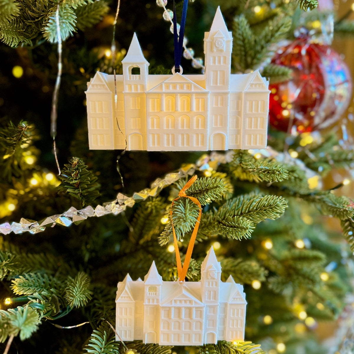 Holiday ornaments for Auburn students, designed as the Samford Hall building and shown on an Auburn tree.