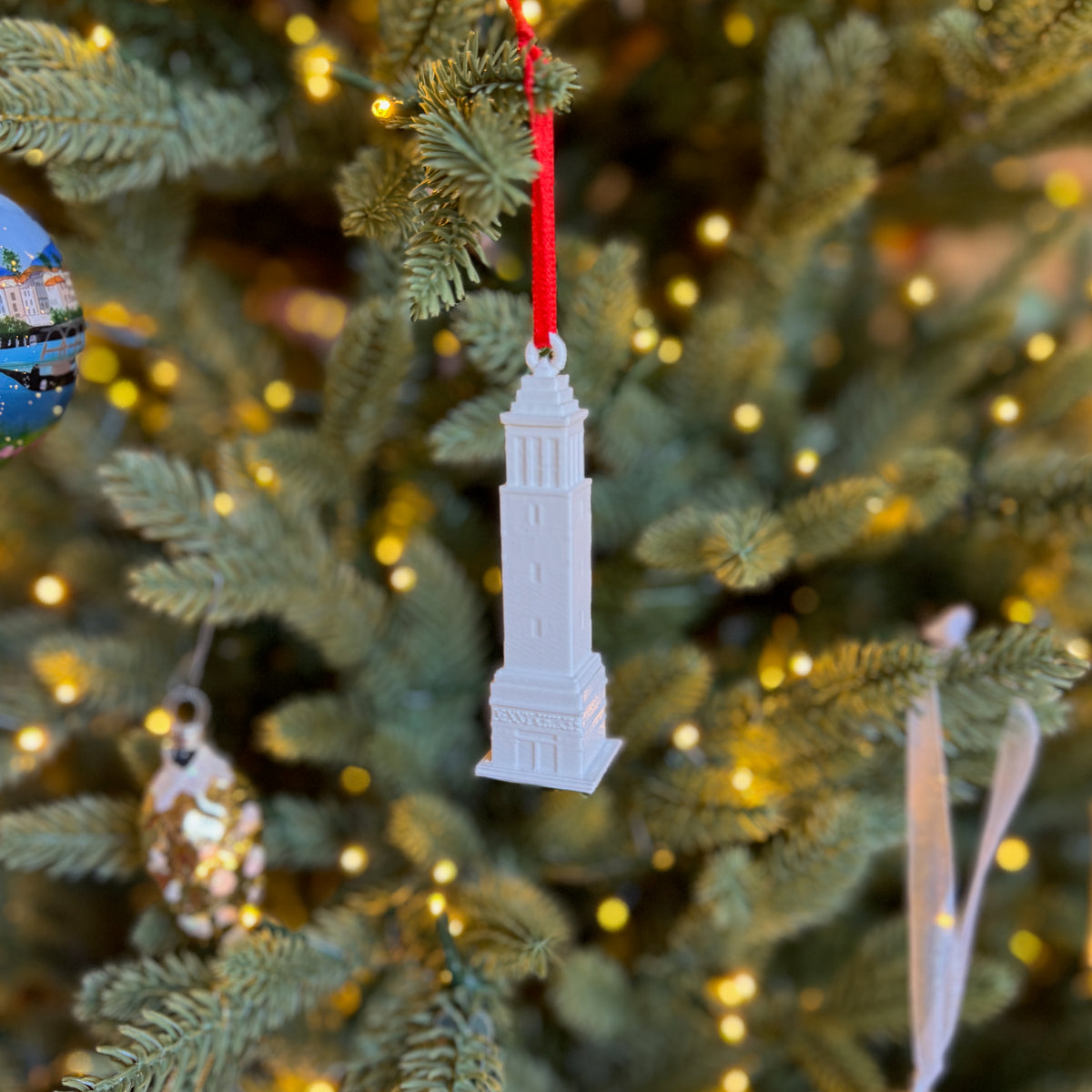 The University of Alabama ornament of Denny Chimes, shown on a Christmas tree.