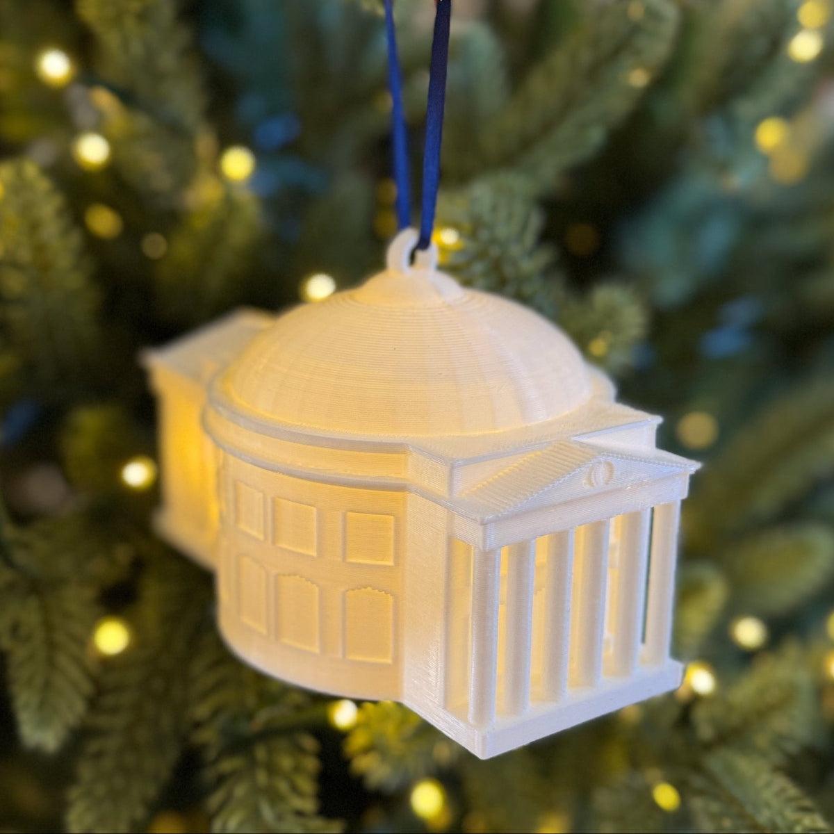 The lighted UVA ornament, featuring the Rotunda and shown on a Christmas tree.