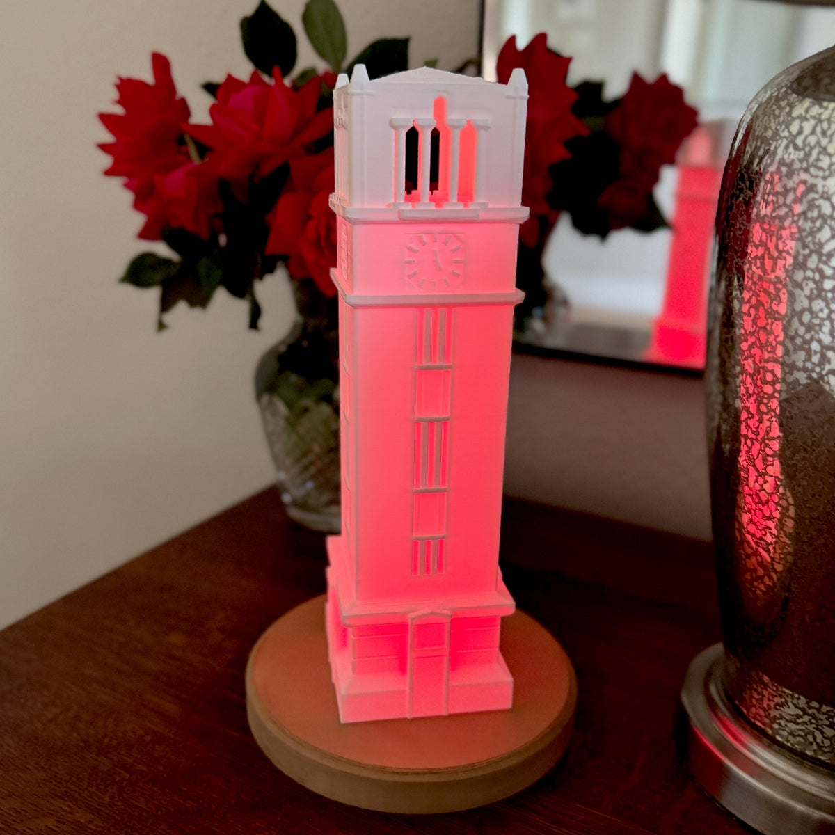 The red LED lighted NC State figurine, shown on a bedroom side table.