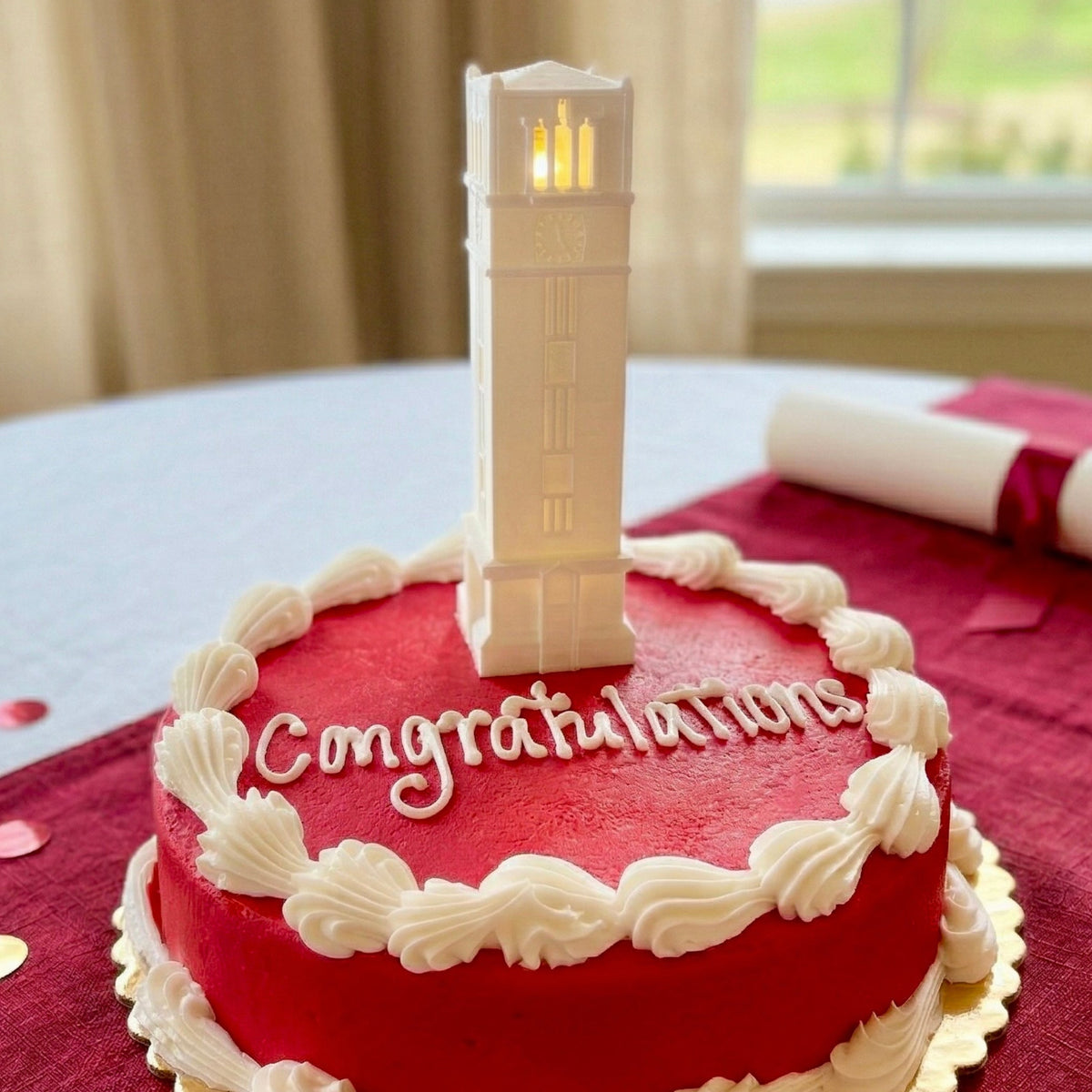The NC State cake topper light featuring the Memorial Tower building on the Raleigh campus and shown on a graduation cake.
