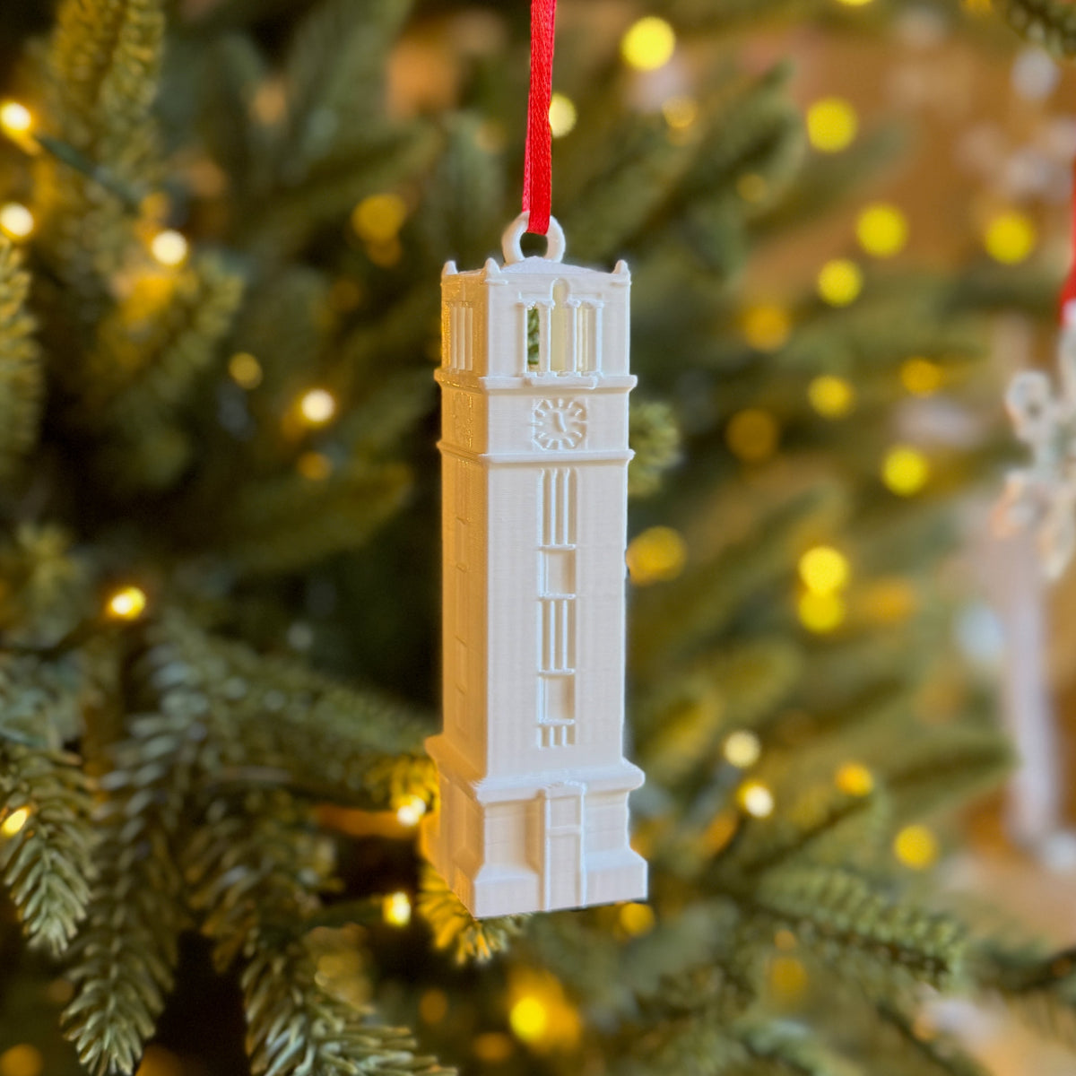The NC State ornament, designed in honor of the Bell Tower, and shown on a Christmas tree.