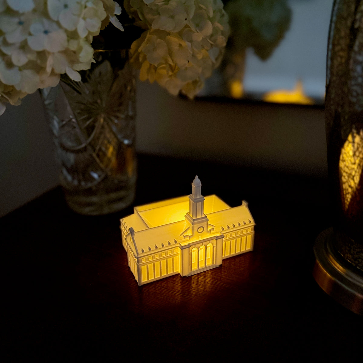 Warm LED light glowing from inside a 3D printed OSU Edmon Low Library bookshelf decoration.