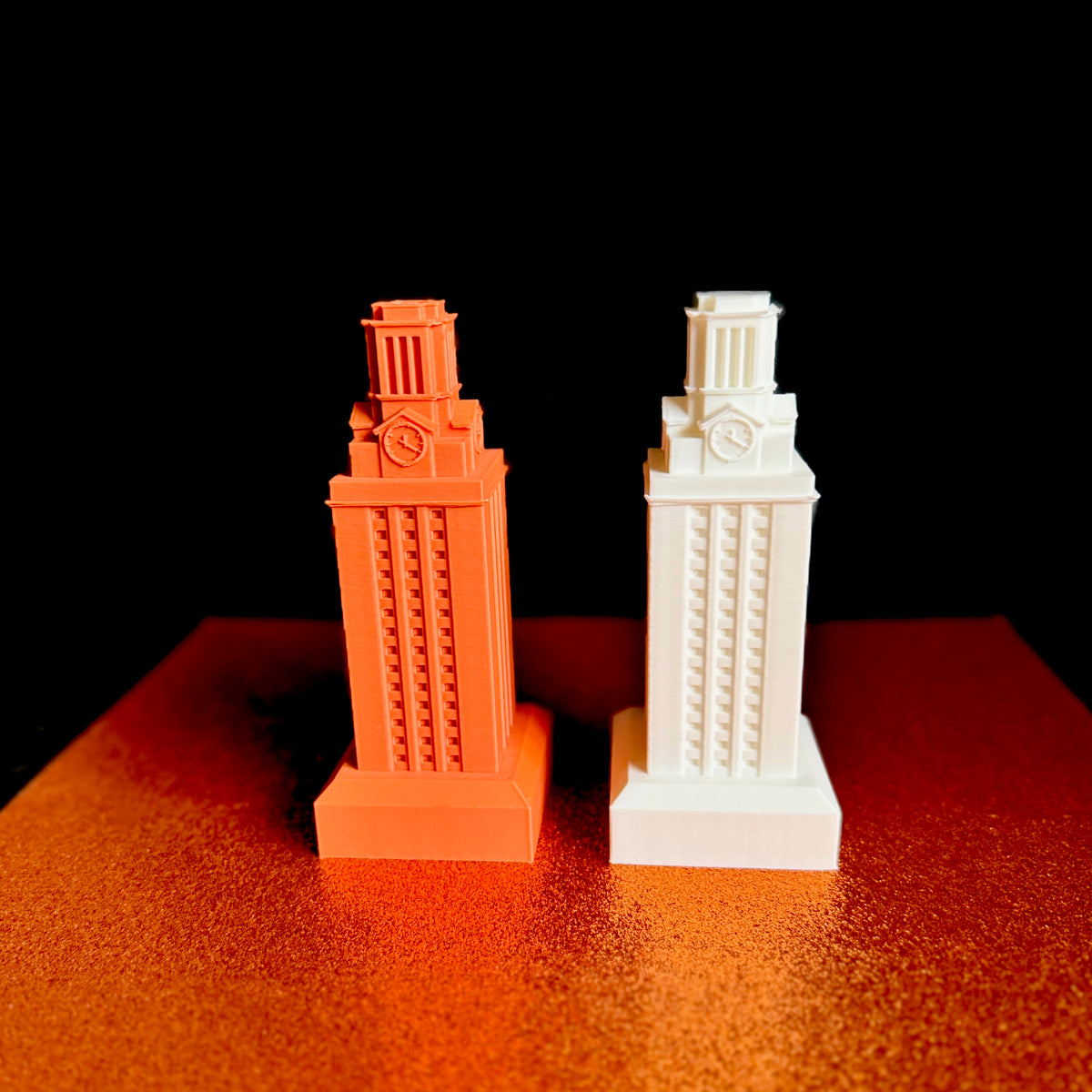 The University of Texas UT Tower figurines, shown in white and burnt orange, and used as a gift idea for a Longhorns alumni.