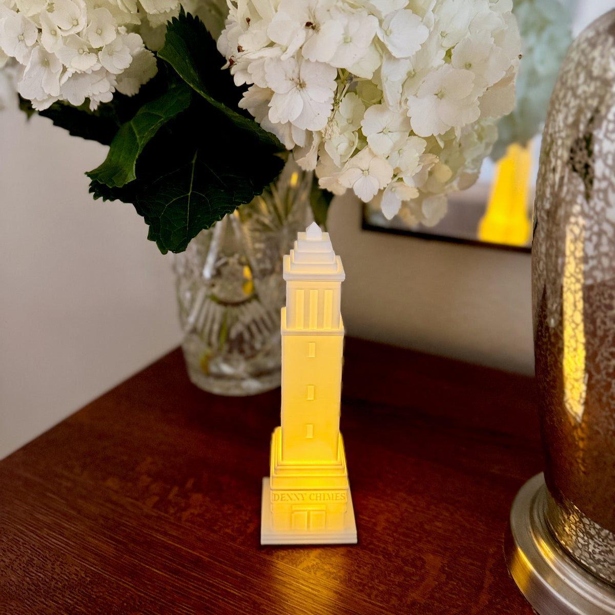 The Denny Chimes night light, a perfect University of Alabama Graduation Gift, shown on a bedroom side table.
