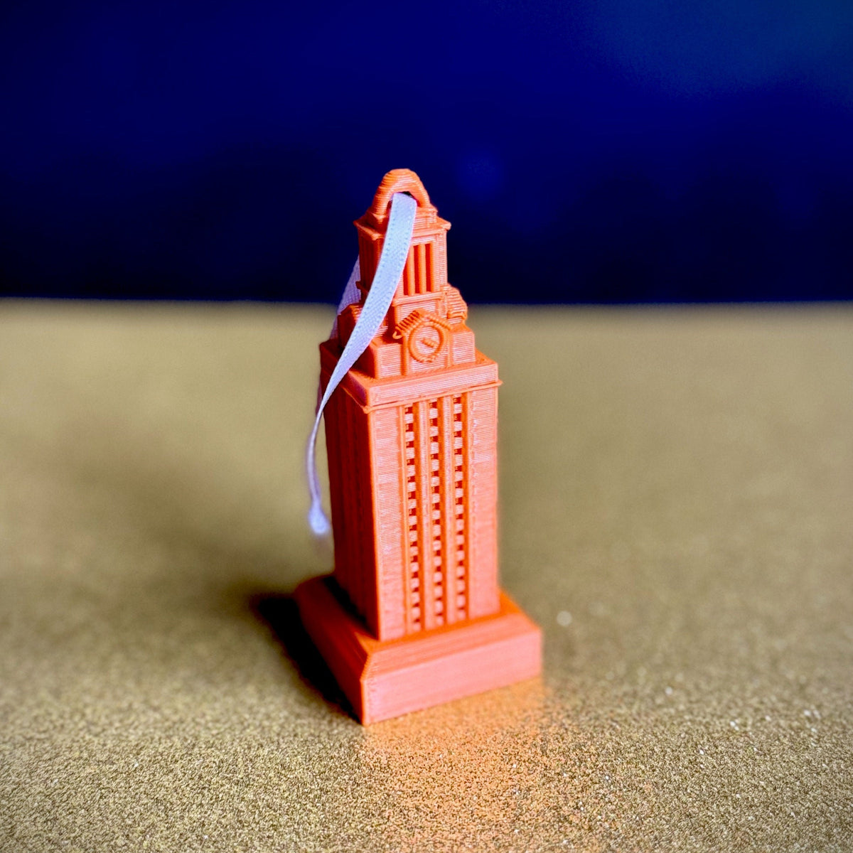 Spotlight photo of the burnt orange UT Tower ornament.