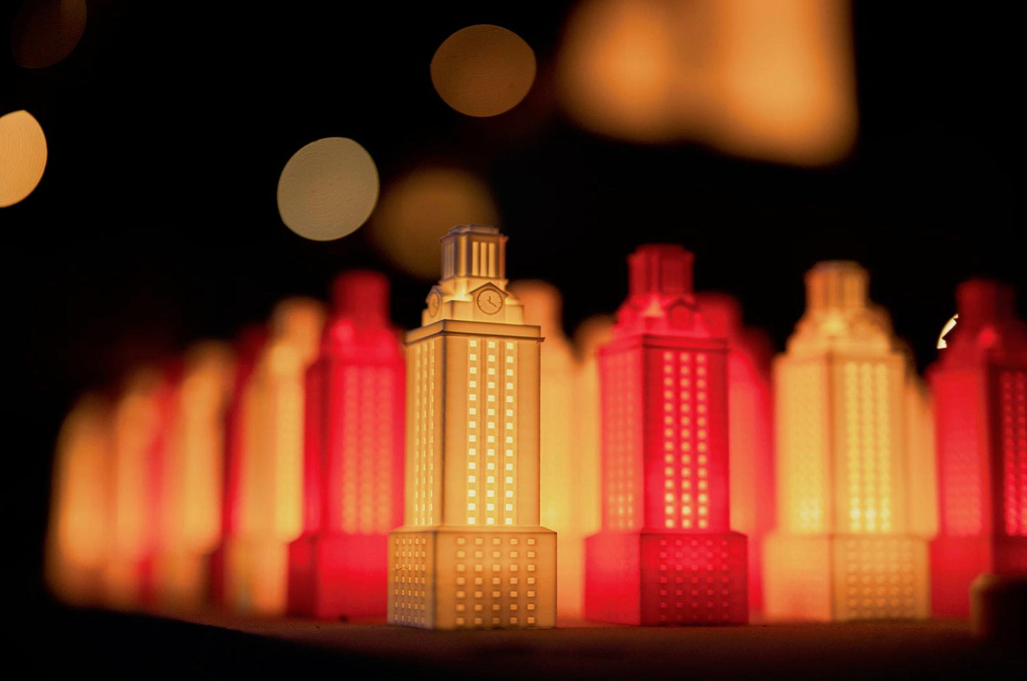 Collection of figurines and ornaments replicating the University of Texas Tower, featuring detailed architectural designs.