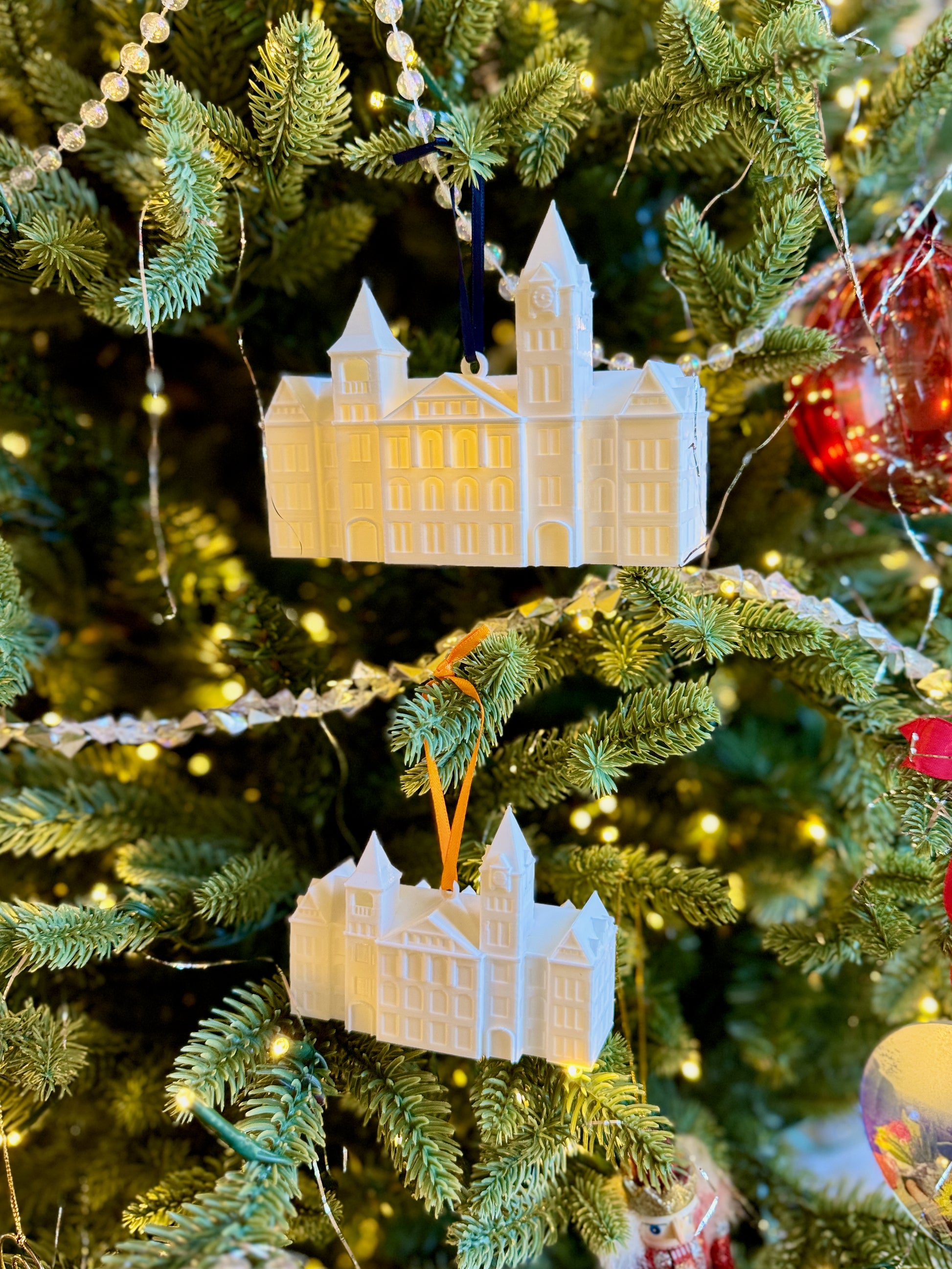 Two Auburn alumni ornaments for the Samford Hall building, shown on a Christmas tree.