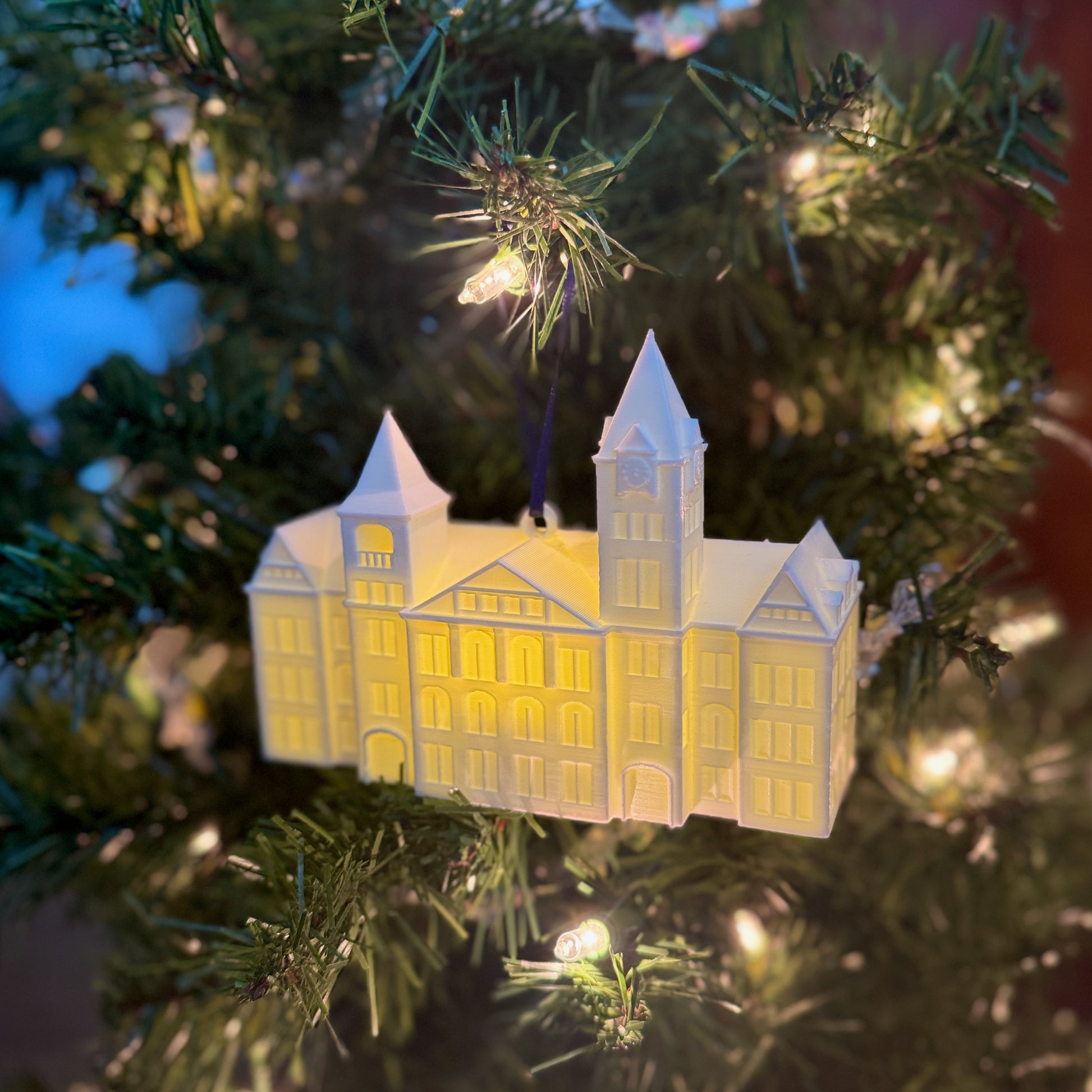 Auburn led ornament of the Samford Hall building, shown on a Christmas tree.