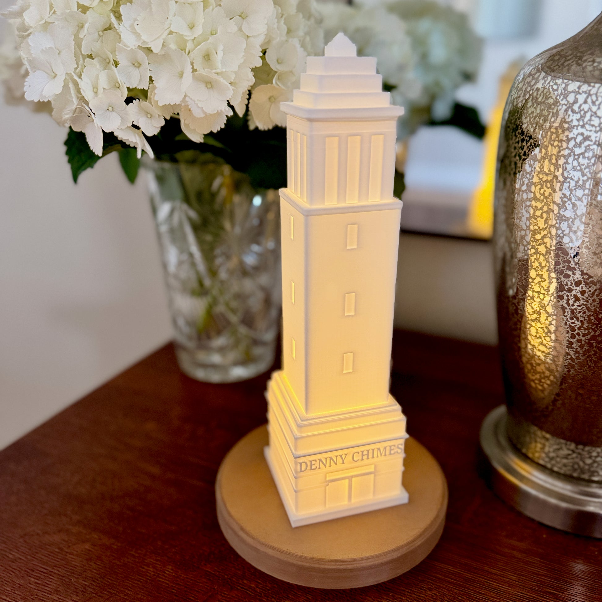 The Denny Chimes LED lamp, perfect as a dorm decoration and shown on a dorm room side table.