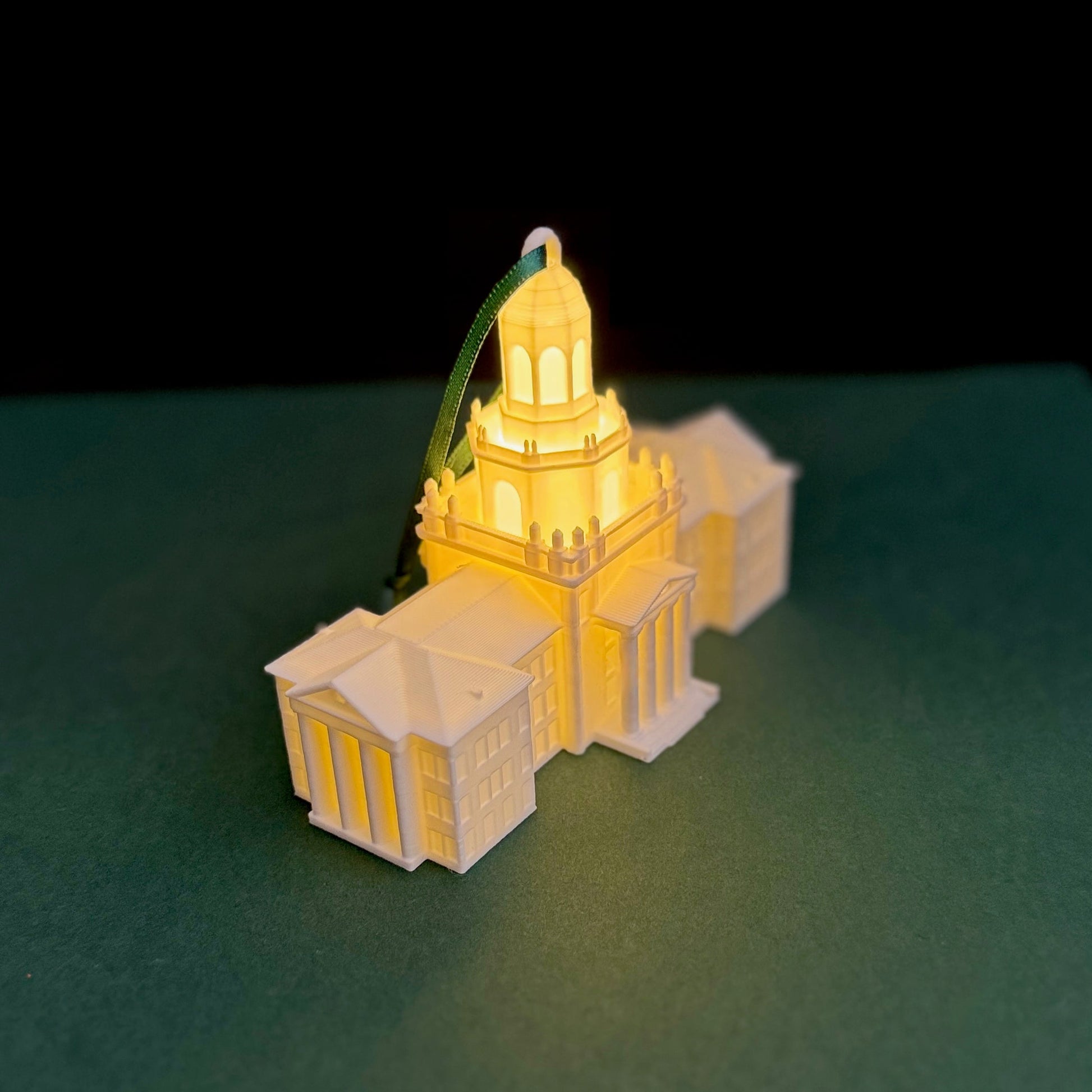Detailed view of the warm LED light glowing from inside a white 3D-printed Baylor University campus keepsake.