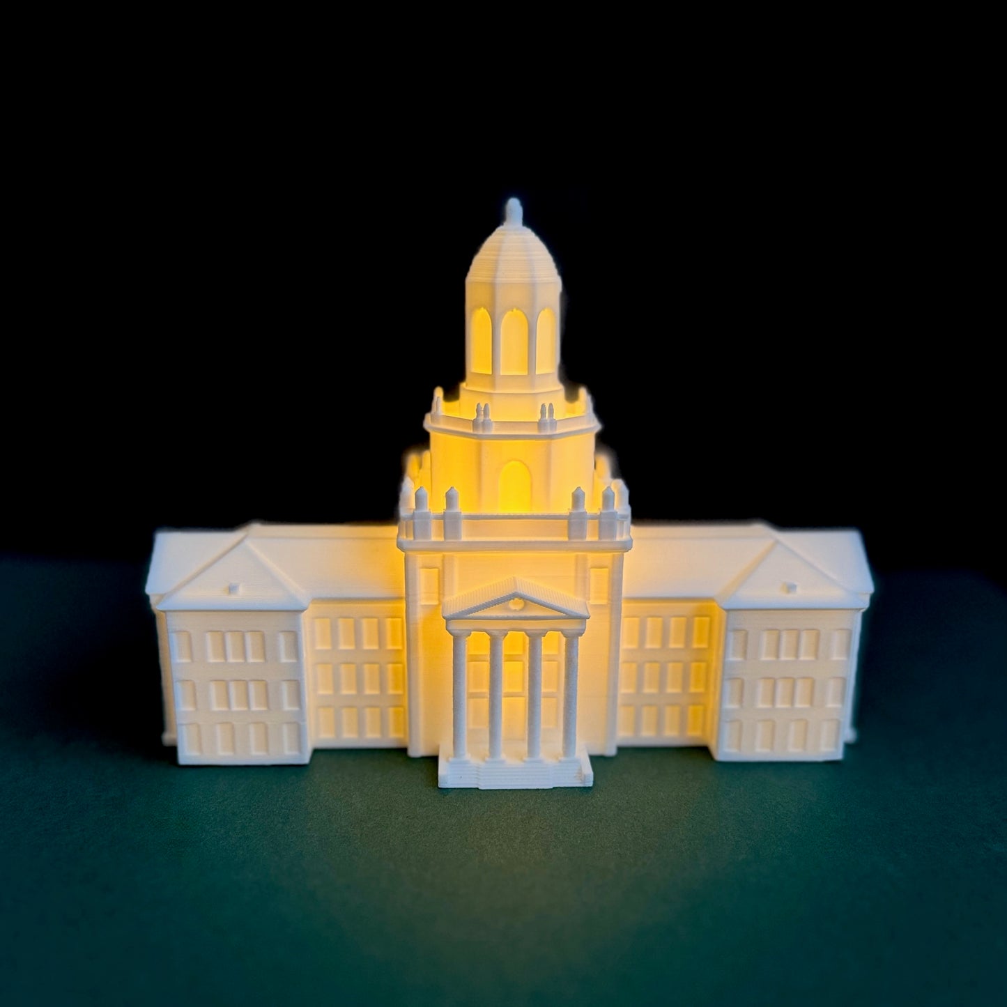 Detailed 3D printed dome of the Baylor Pat Neff Hall light-up cake topper shining brightly in a dimly lit room.