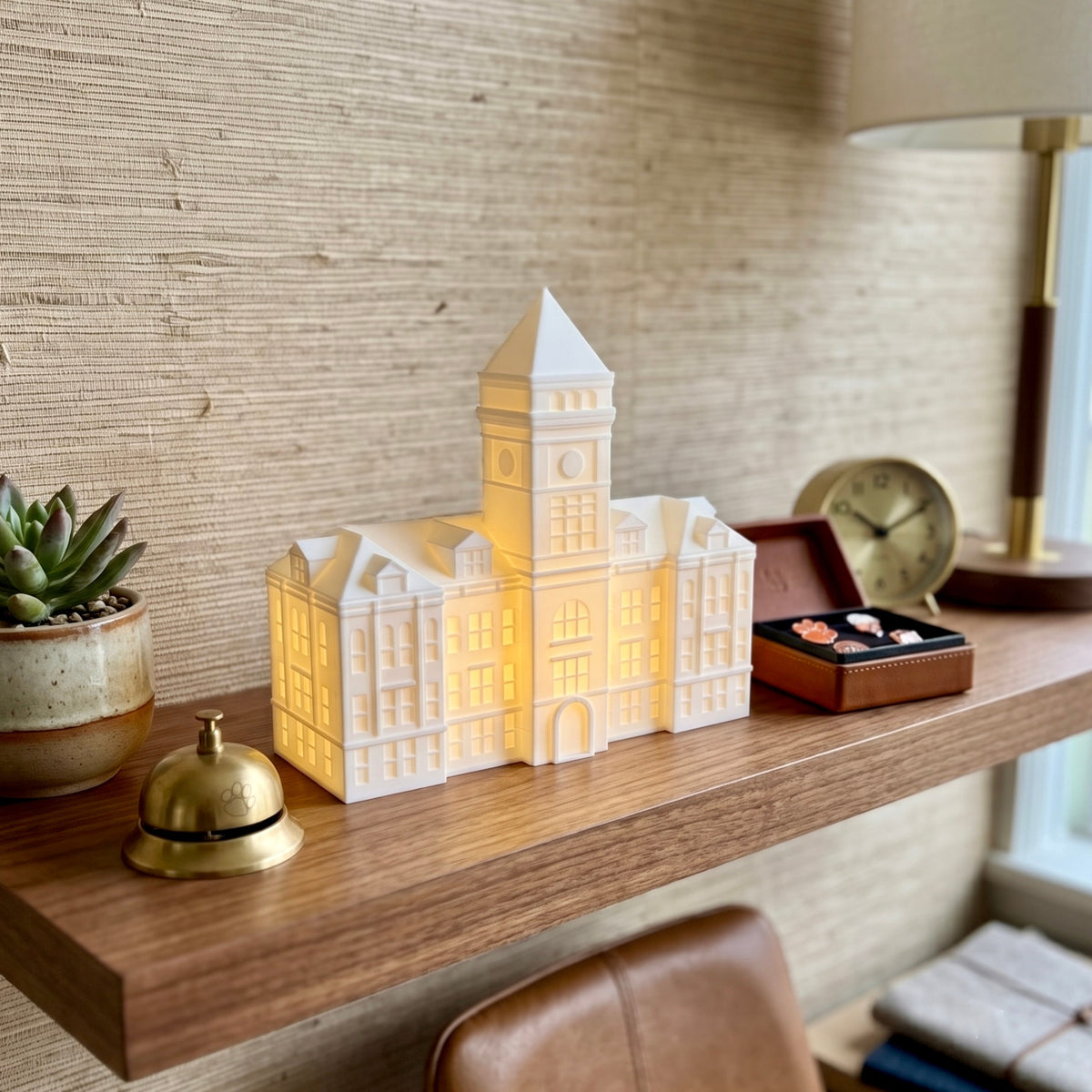 The Clemson LED figurine designed as the Tillman Hall building and used as office decor on the shelf of a Clemson alumni.