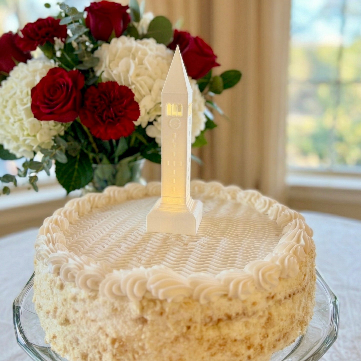 The Cornell University cake topper figurine designed as a replica of the McGraw Tower building and shown on a groom's cake or graduation cake.