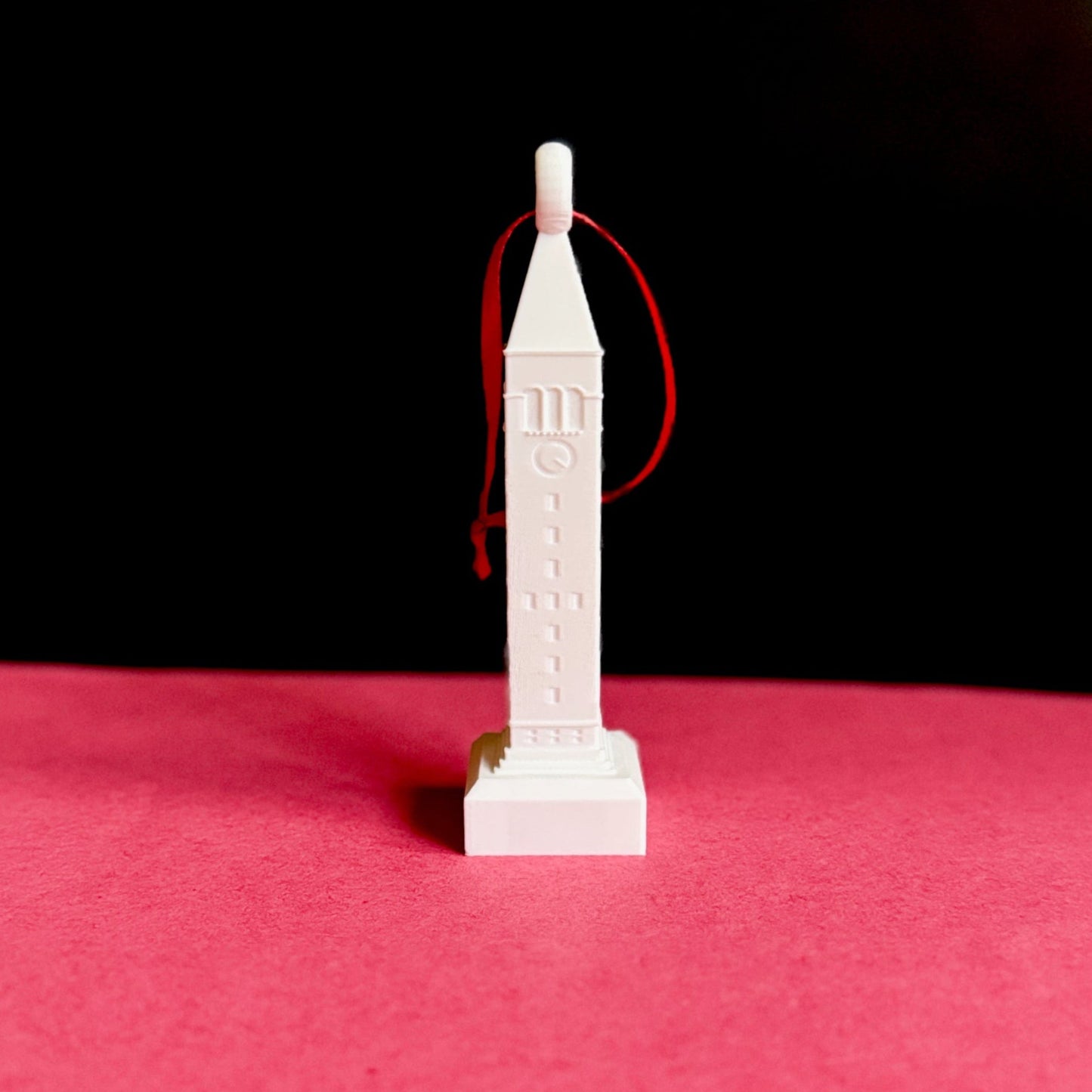 White 3D printed McGraw Tower ornament with red ribbon, perfect for holiday home décor.