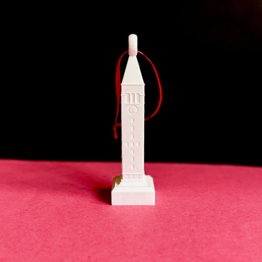 White 3D printed McGraw Tower ornament with red ribbon, perfect for holiday home décor.