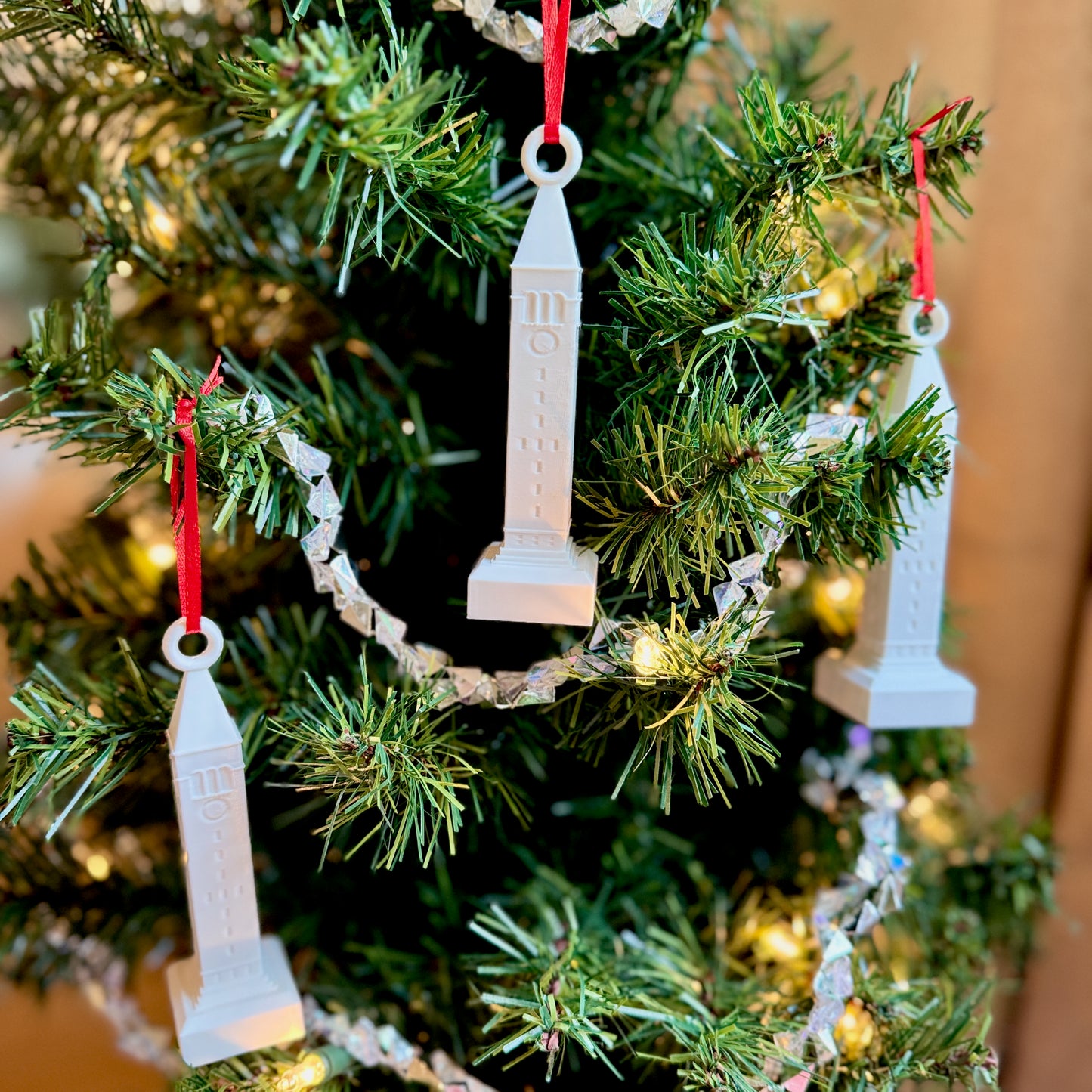Cornell University McGraw Tower ornaments displayed as festive holiday decorations on a Christmas tree.