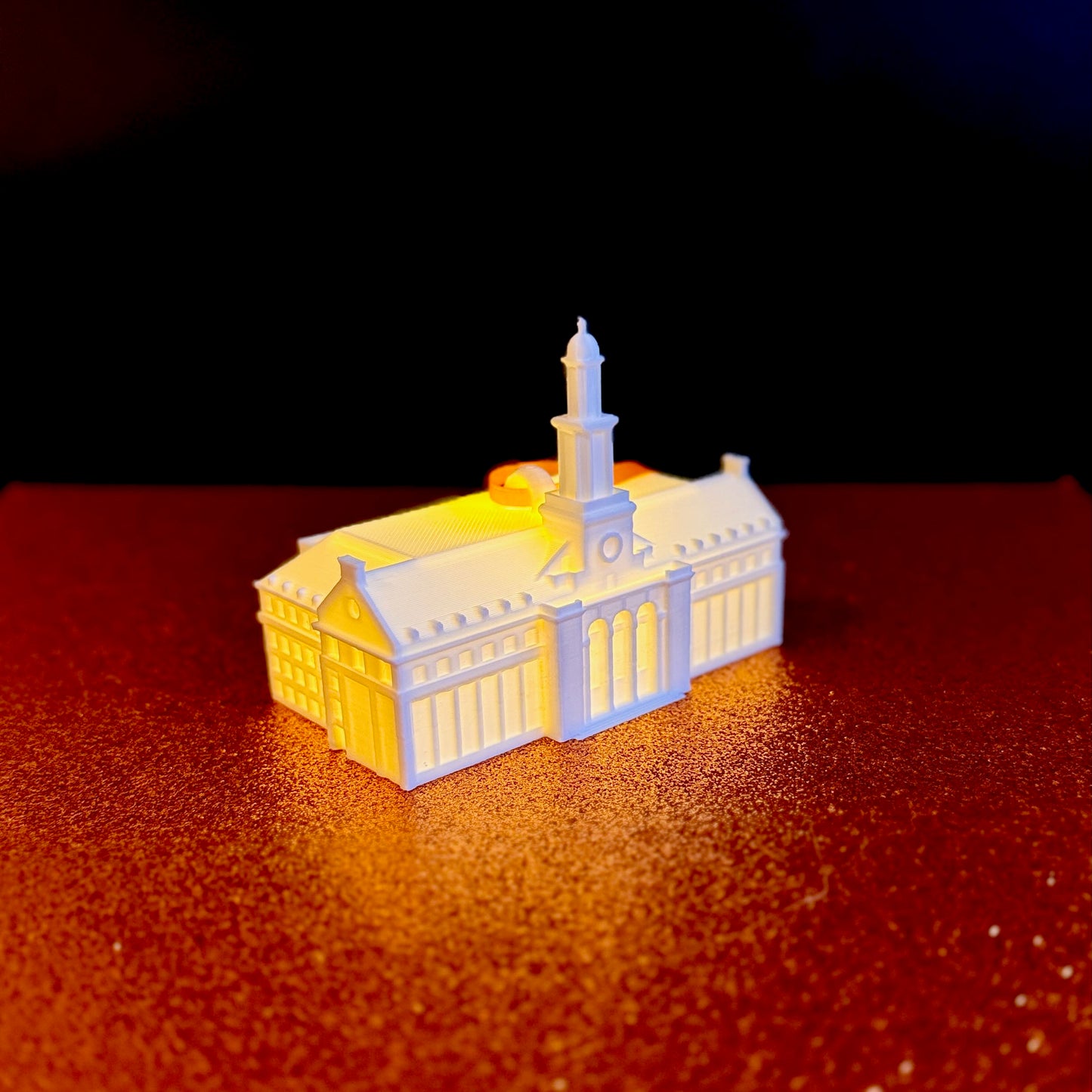 Lighted 3D printed Oklahoma State University Edmon Low Library ornament with an orange hanging ribbon.