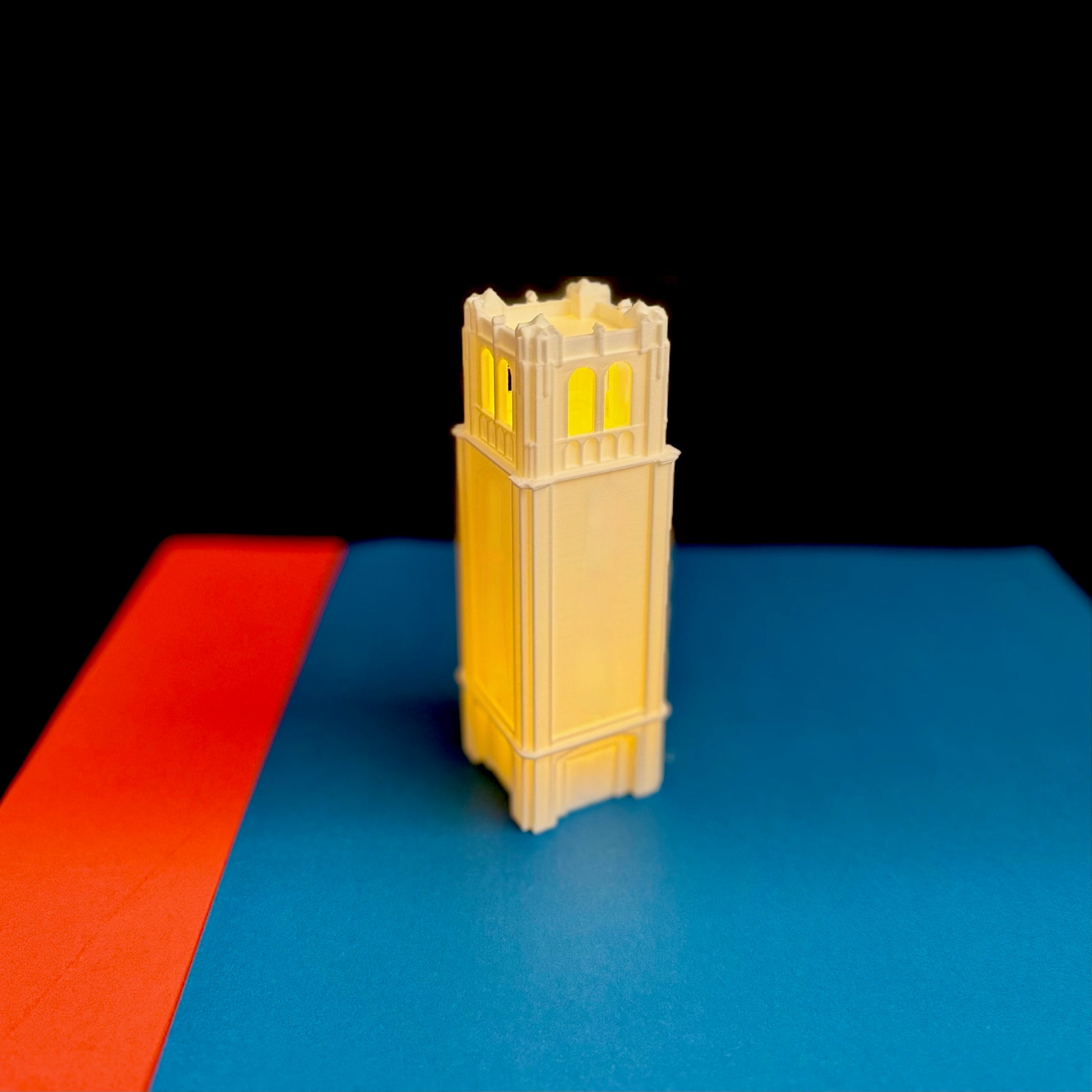 The Florida Gators Century Tower figurine, shown against a background of school colors.