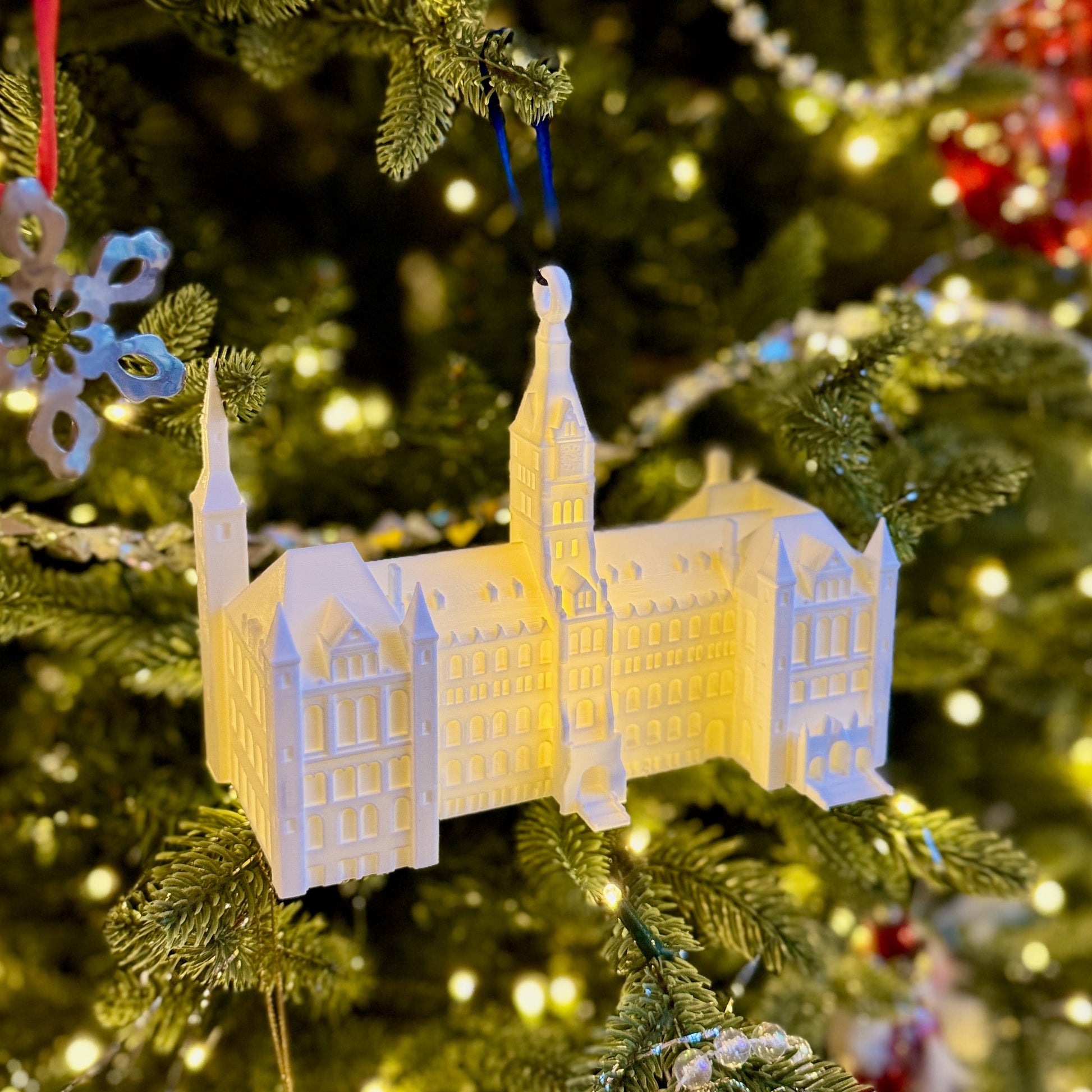 Decorative ornament of the Georgetown Healy Hall building on a Christmas tree with lights and ornaments.