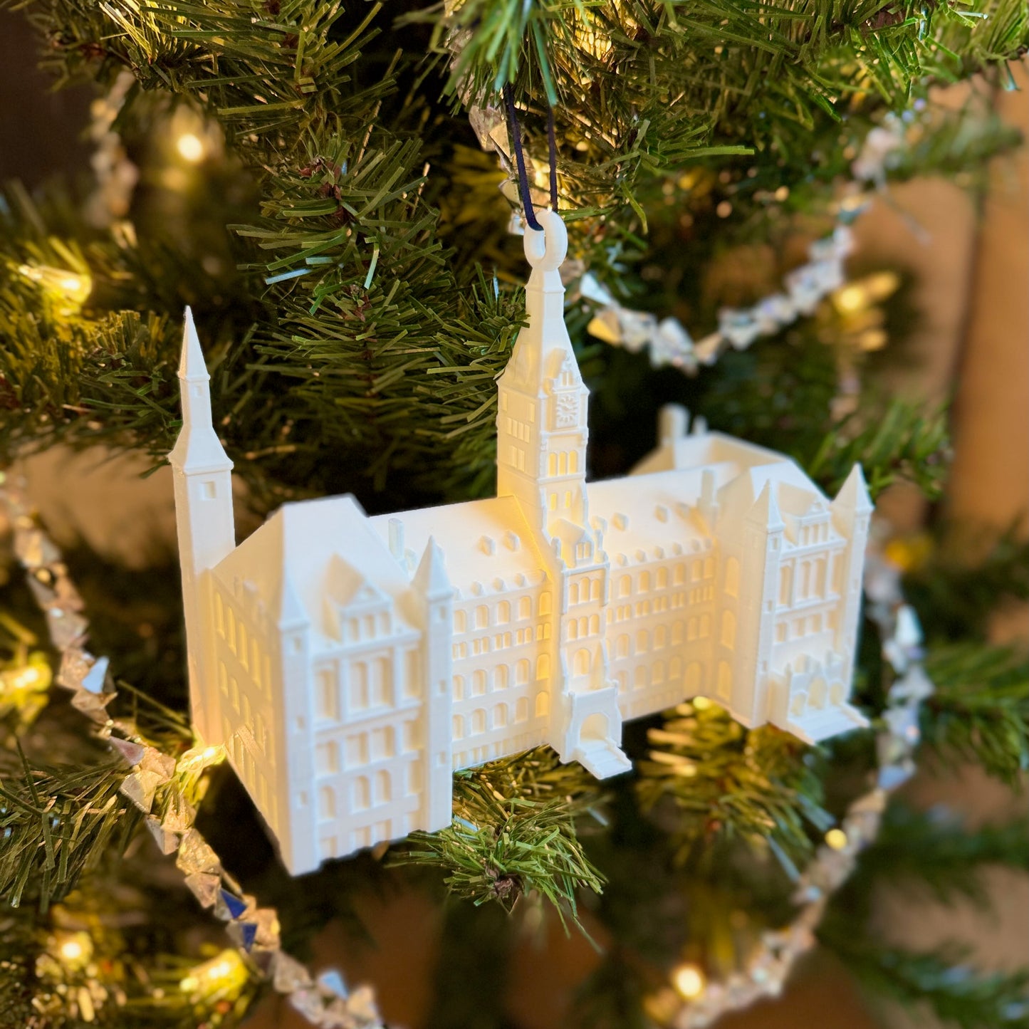The lighted ornament of the Georgetown Healy Hall building, shown on a Christmas tree.