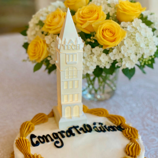 The Georgia Tech cake topper with an LED light, designed as a replica of the Tech Tower building on the Atlanta campus and shown on a graduation cake or a groom's cake.