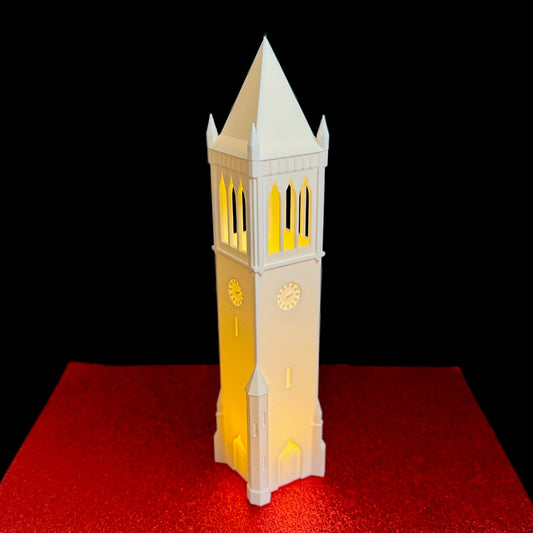 Front profile of an illuminated 3D printed Iowa State Campanile replica isolated on a white background.