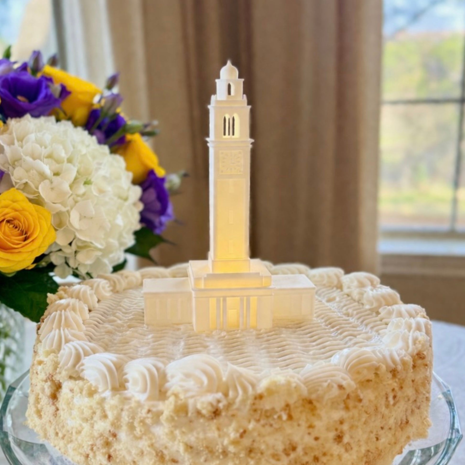 The LSU cake topper with LED light, designed as a replica of the Memorial Tower building on the Baton Rouge campus and shown on a graduation cake or groom's cake.