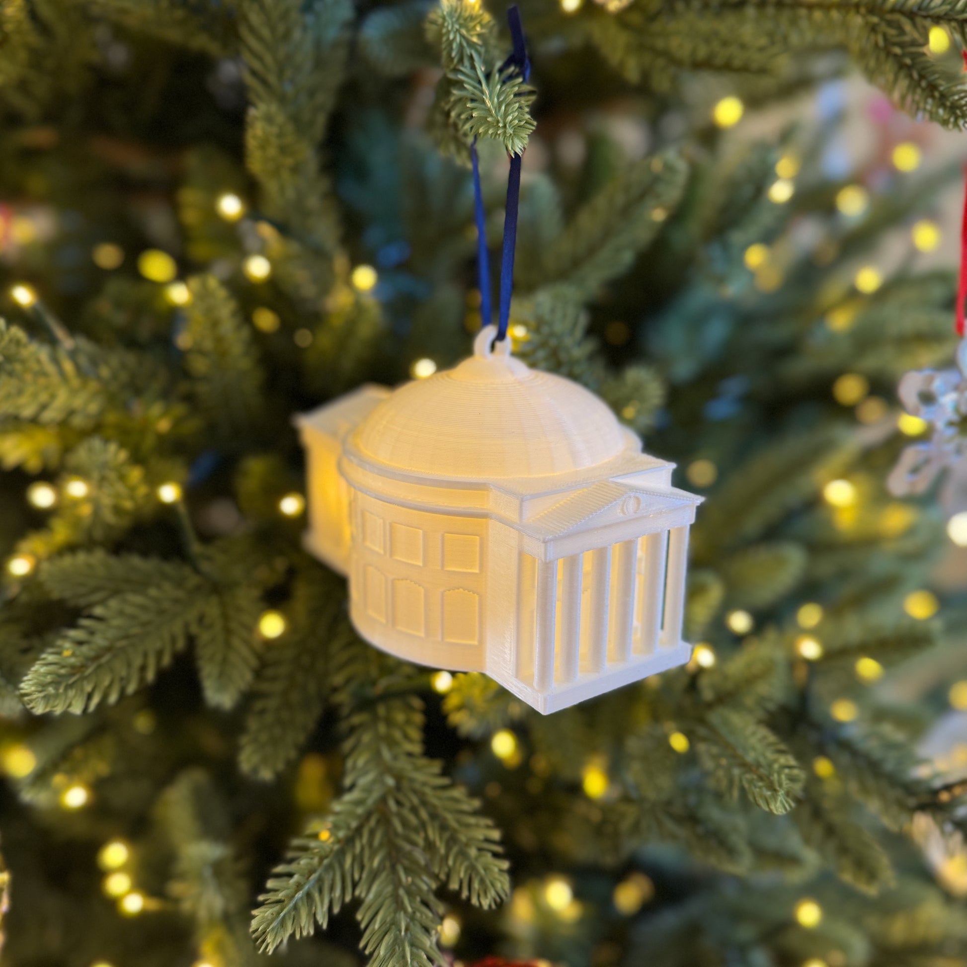 The lighted UVA ornament, featuring the Rotunda and shown on a Christmas tree.