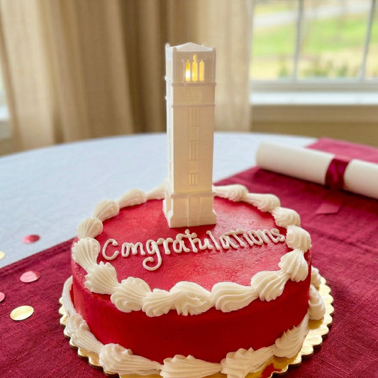 The NC State cake topper light featuring the Memorial Tower building on the Raleigh campus and shown on a graduation cake.