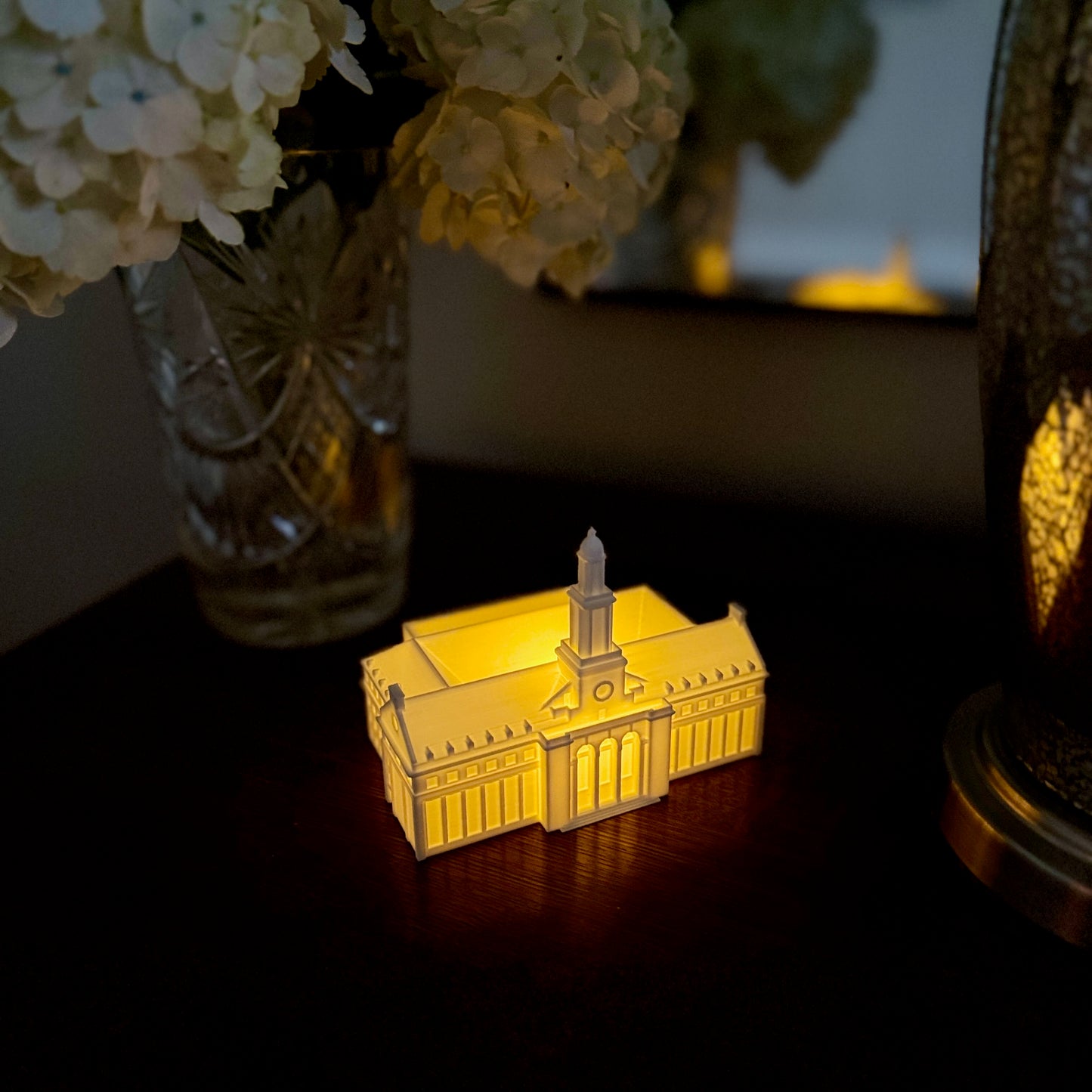 Warm LED light glowing from inside a 3D printed OSU Edmon Low Library bookshelf decoration.