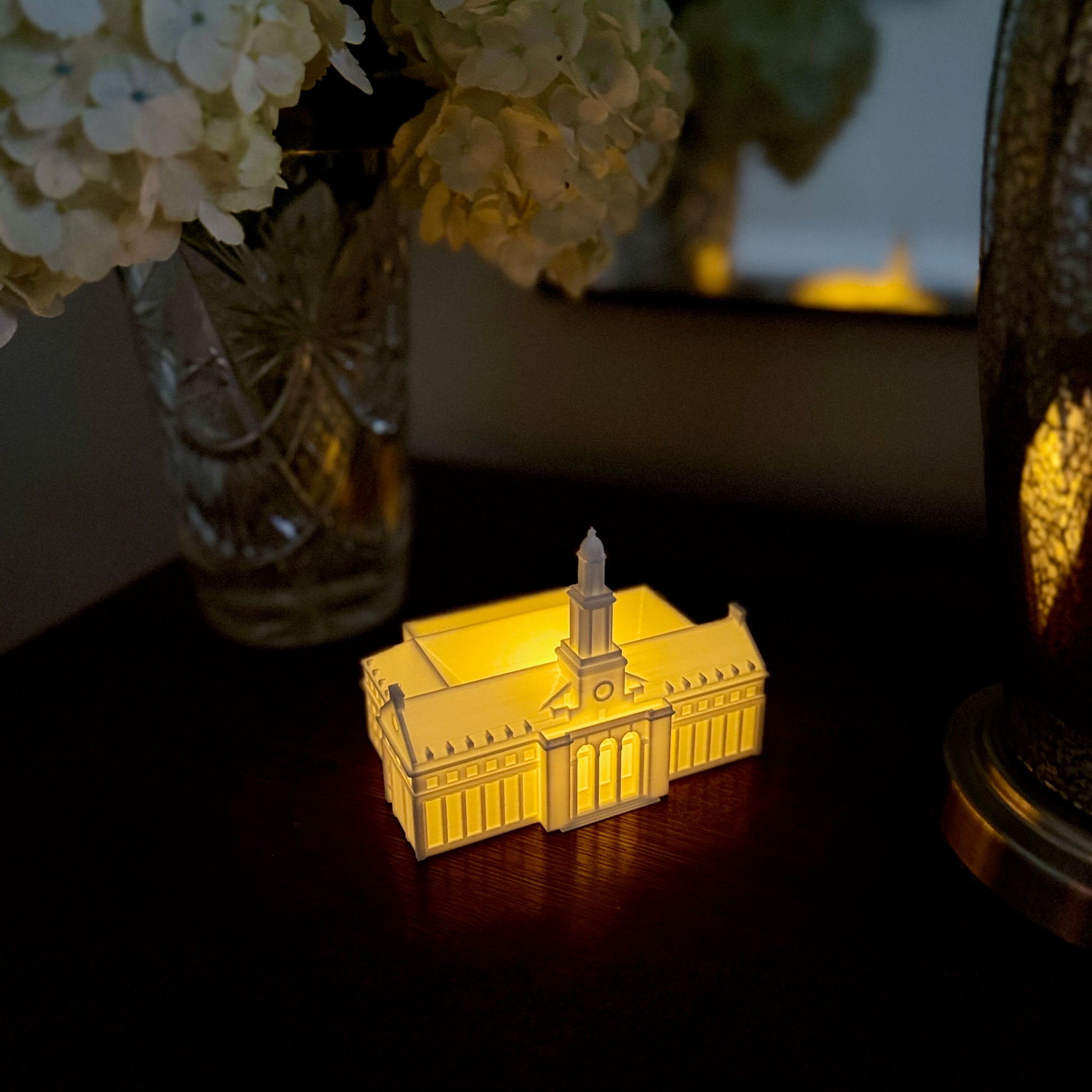 Warm LED light glowing from inside a 3D printed OSU Edmon Low Library bookshelf decoration.