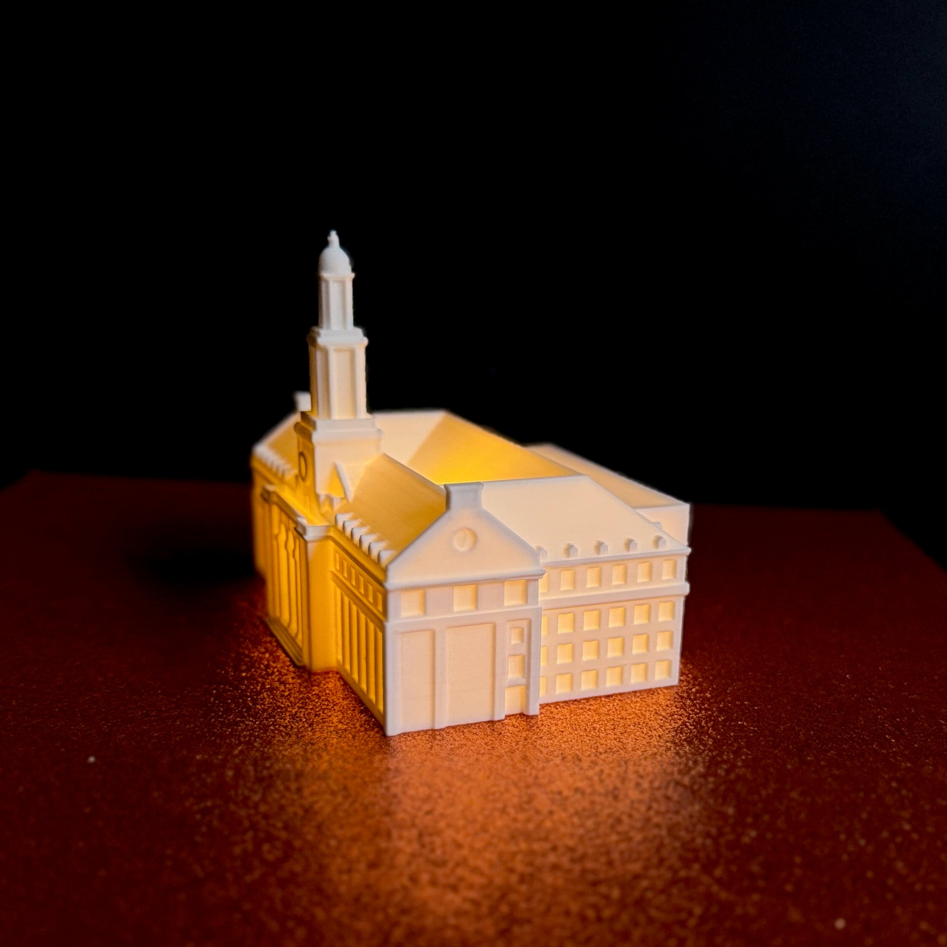 Warm LED light glowing from inside a 3D printed OSU Edmon Low Library bookshelf decoration.