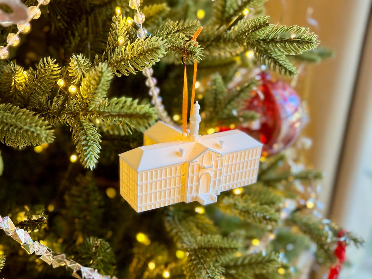 Princeton graduation ornament shown from a side view and designed as the Nassau Hall building with an LED light.