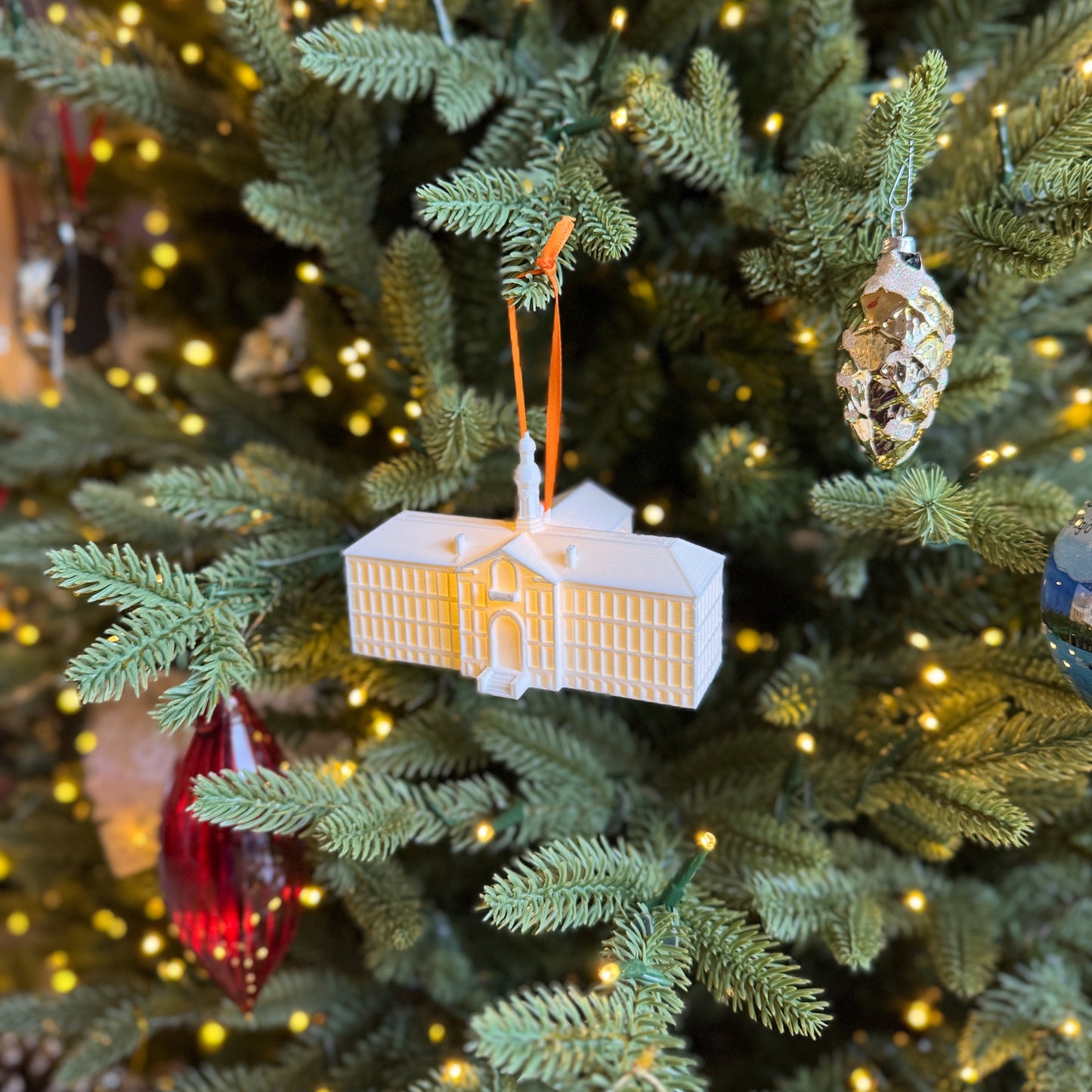 Side view of the Princeton campus ornament, shown on a Princeton tree.