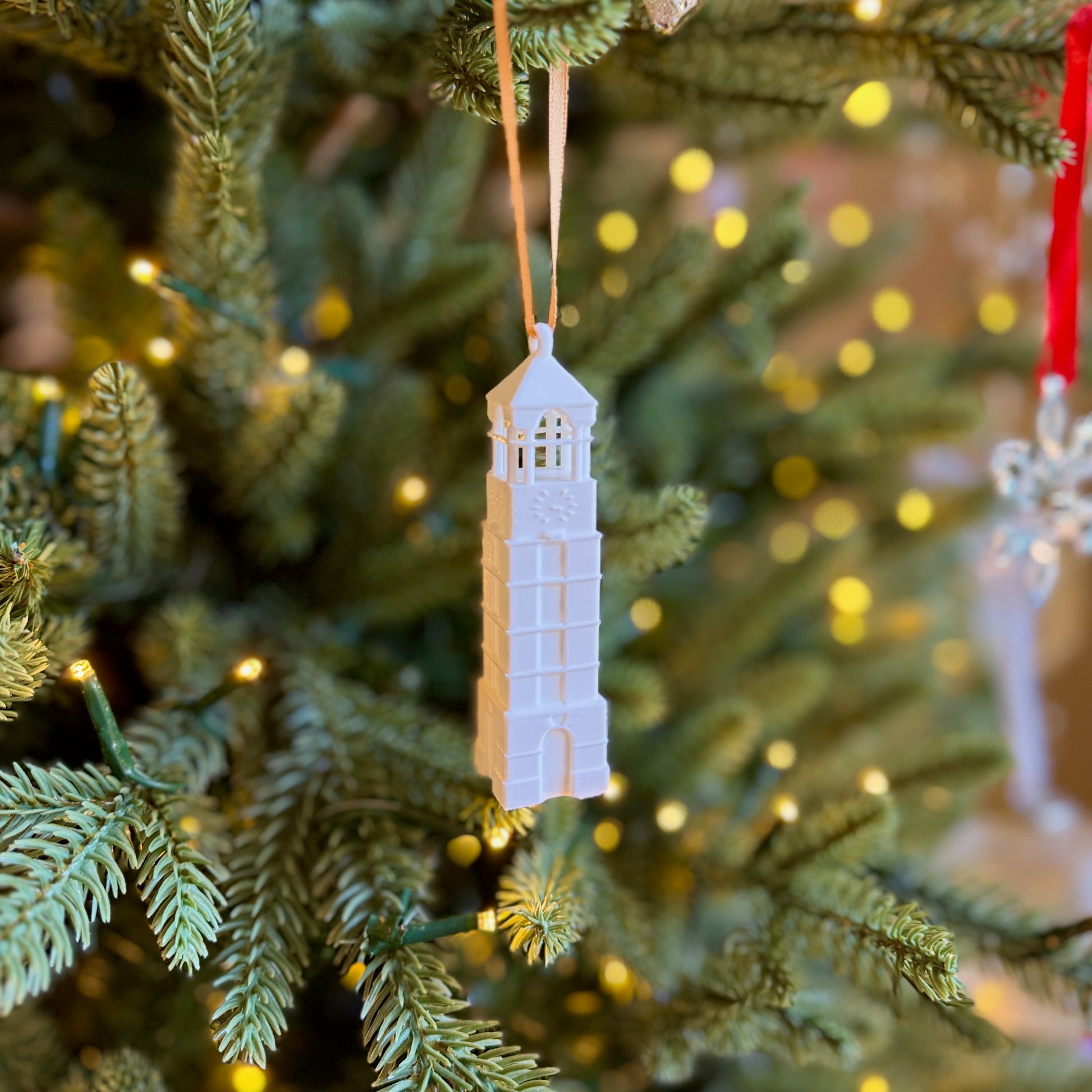The Purdue Bell Tower ornament shown on a Christmas tree.