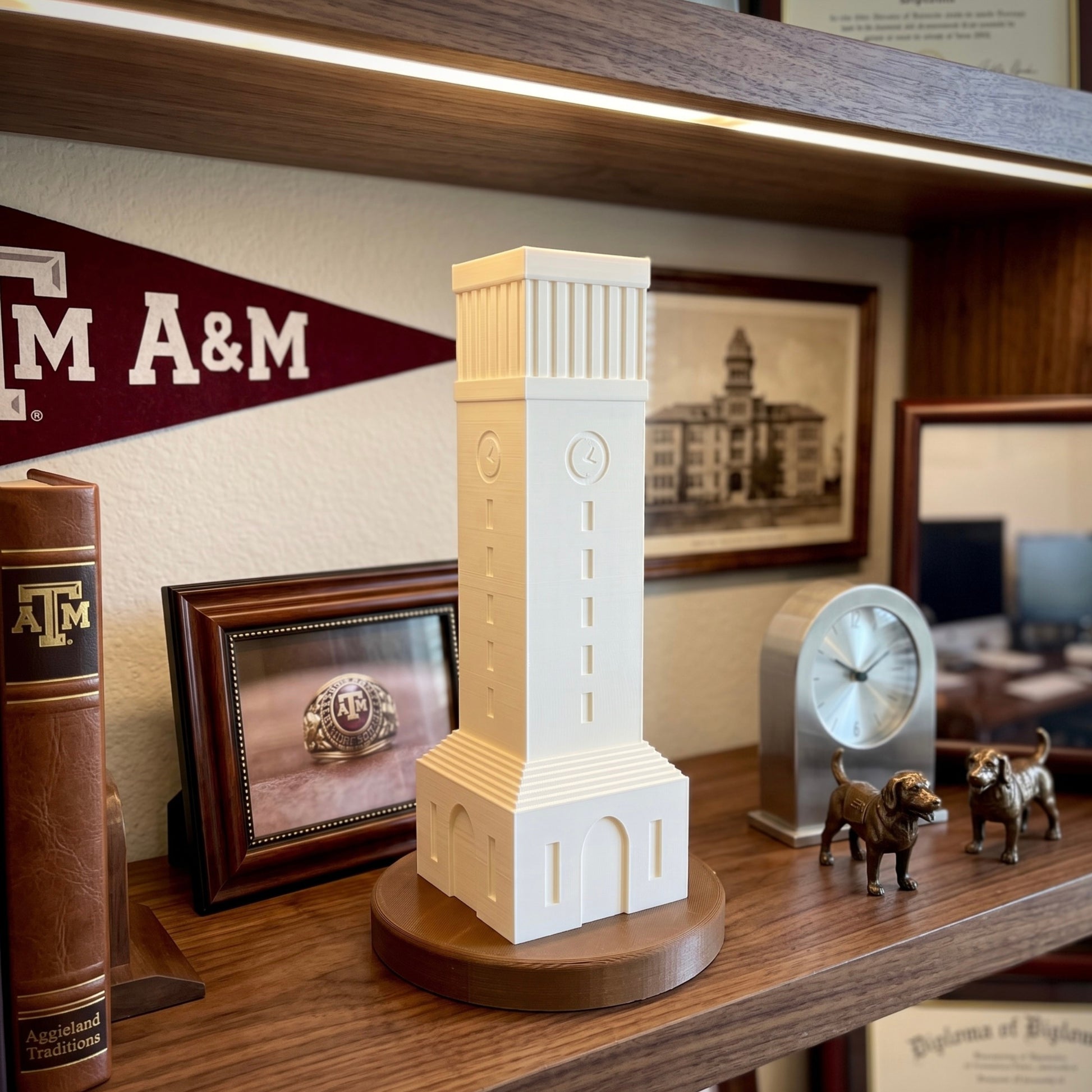 Texas A&M Albritton Tower 3D printed light displayed on a wooden office shelf next to an Aggie ring photo and vintage memorabilia.