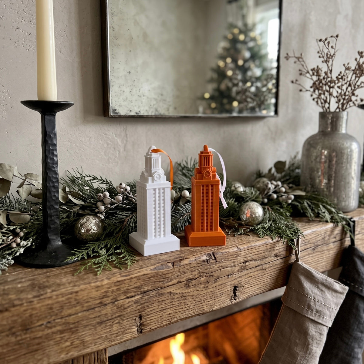 A white and burnt orange UT Tower ornament shown on a mantle of a Texas Longhorns fan that is decorated for the holidays.