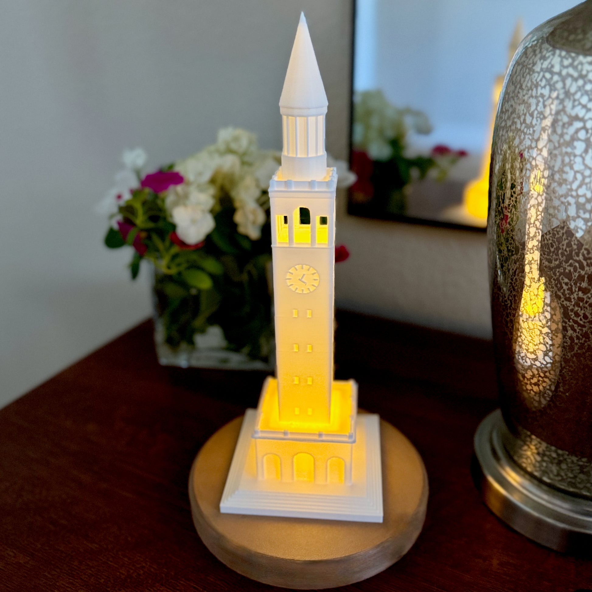3D printed UNC Bell Tower LED model on bookshelf with other Tar Heel memorabilia