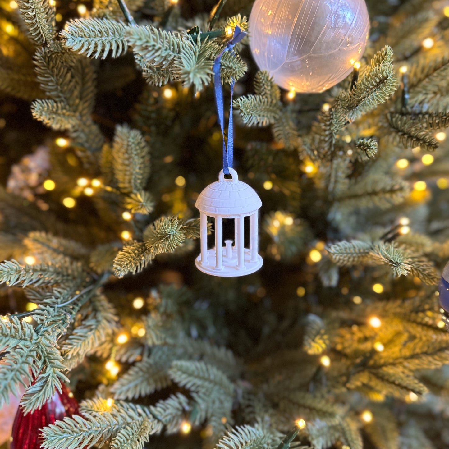 UNC Old Well Ornament, shown on a Christmas tree.