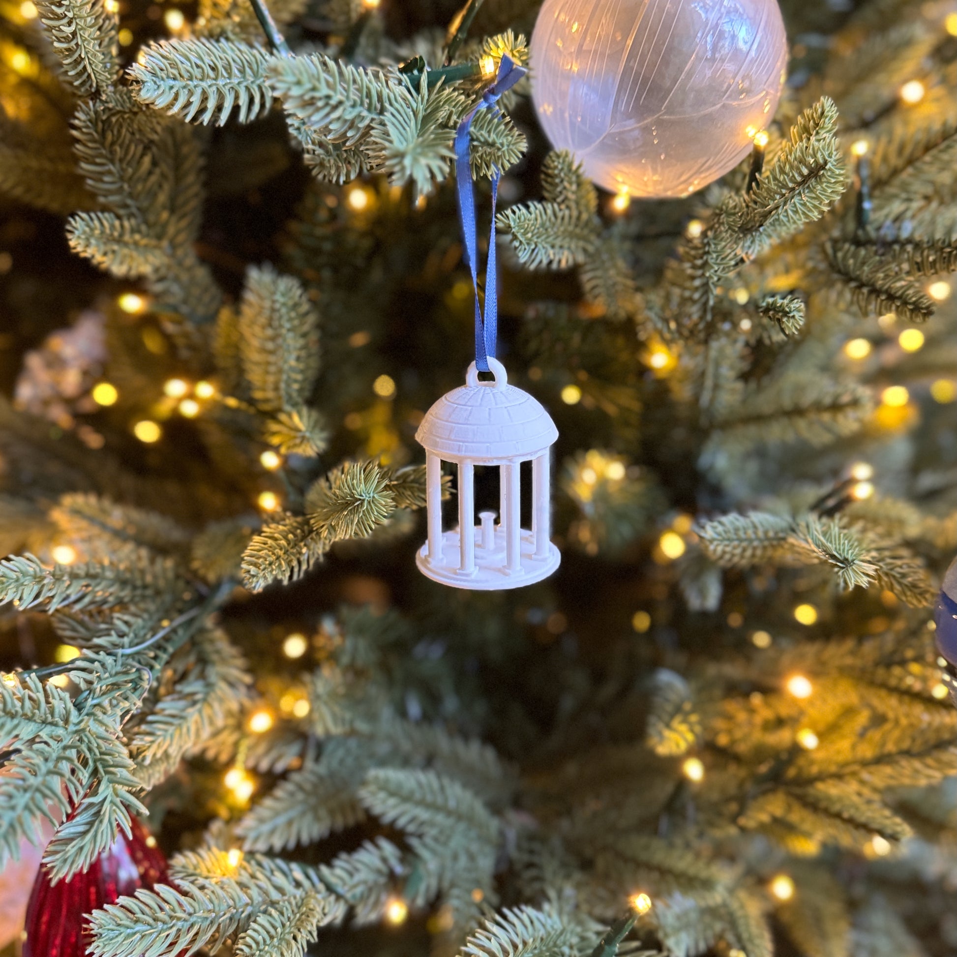 UNC Old Well Ornament, shown on a Christmas tree.