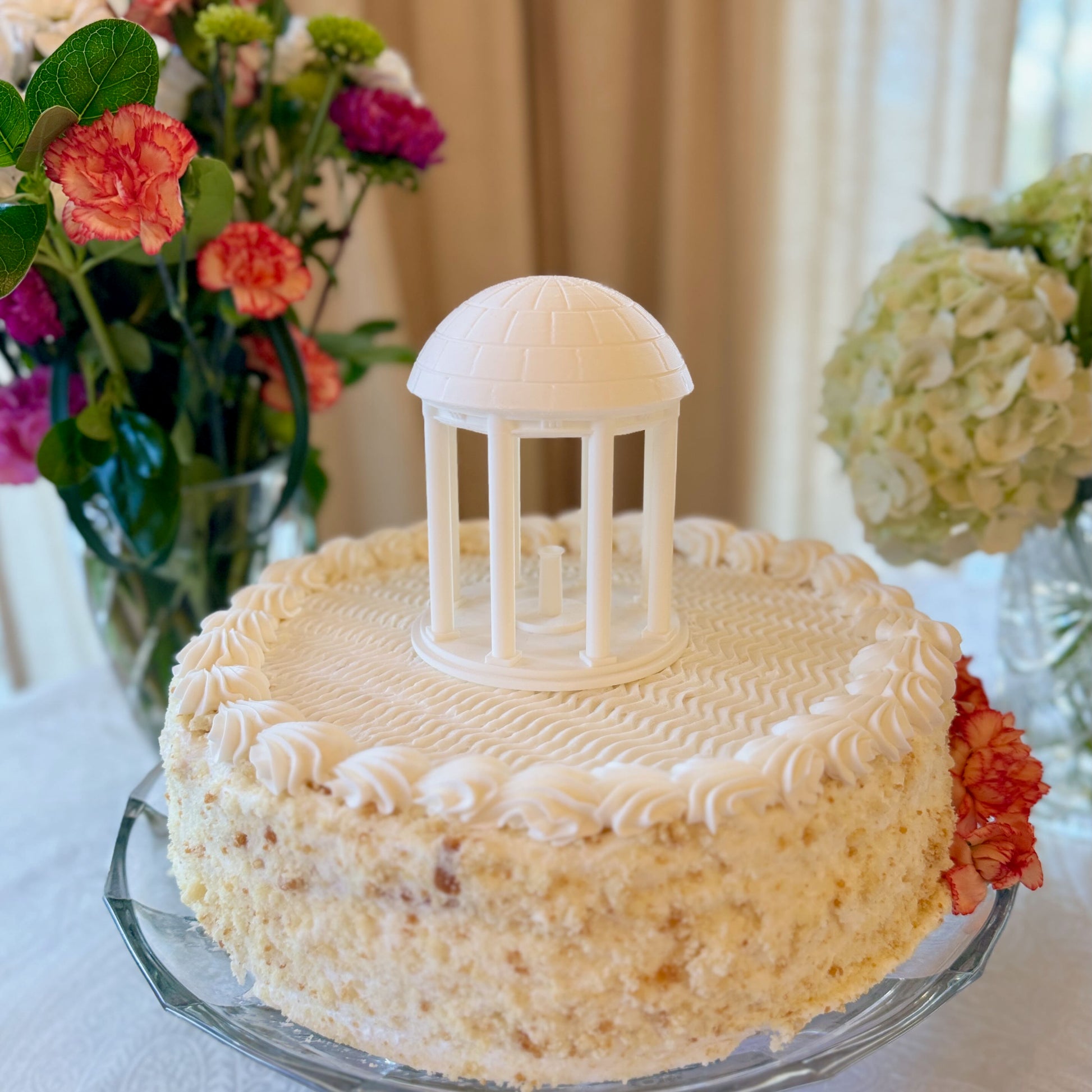 The UNC Old Well cake topper figurine, shown on a UNC graduation cake.