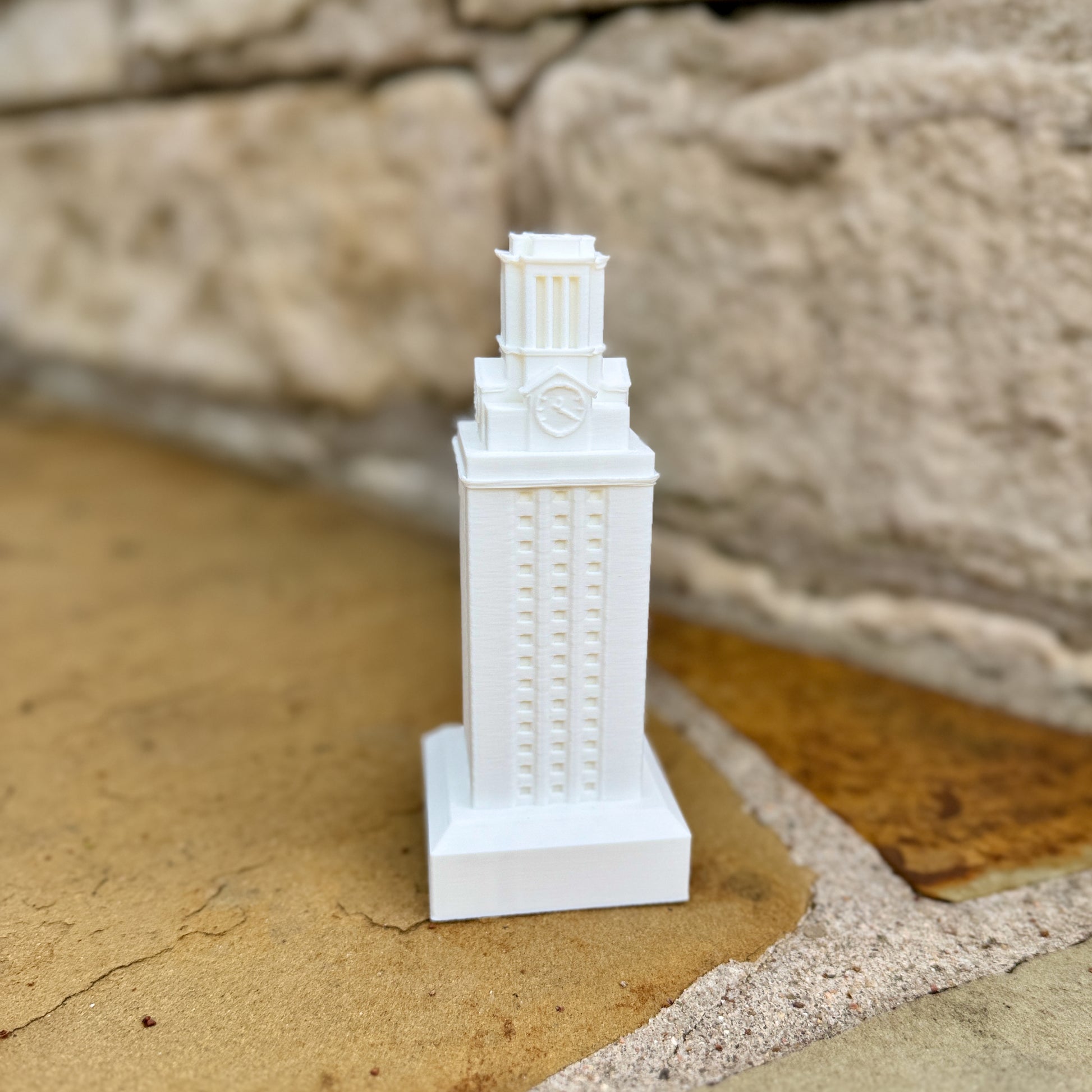 White and burnt orange UT Tower statues showing architectural details of the campus tower.
