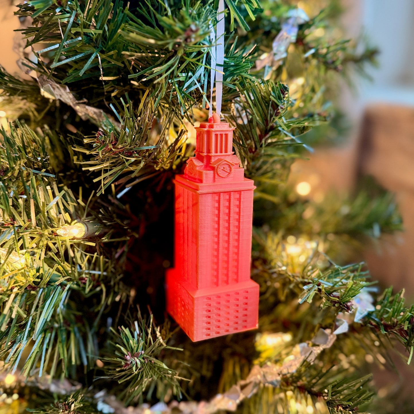 The orange lit University of Texas ornament, shown on a UT Christmas tree decoratedfor the holidays.