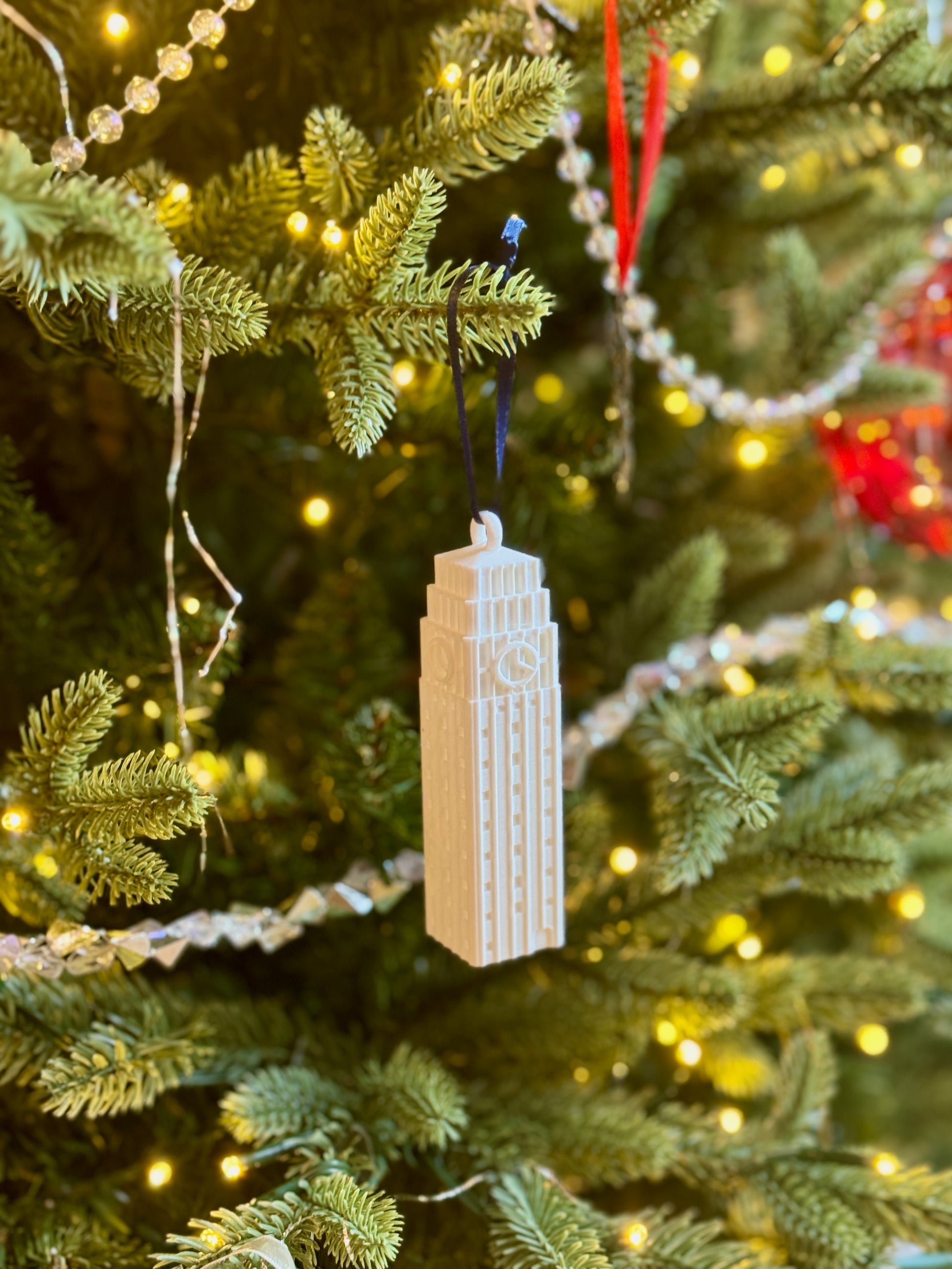 The University of Michigan ornament for alumni, featuring the Burton Tower and shown on a Christmas tree.