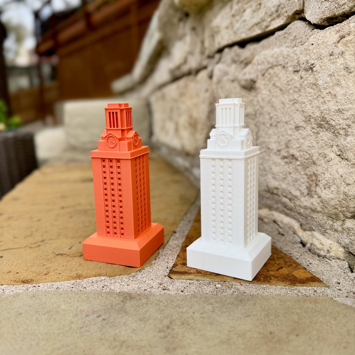 White and burnt orange UT Tower statues showing architectural details of the campus tower.
