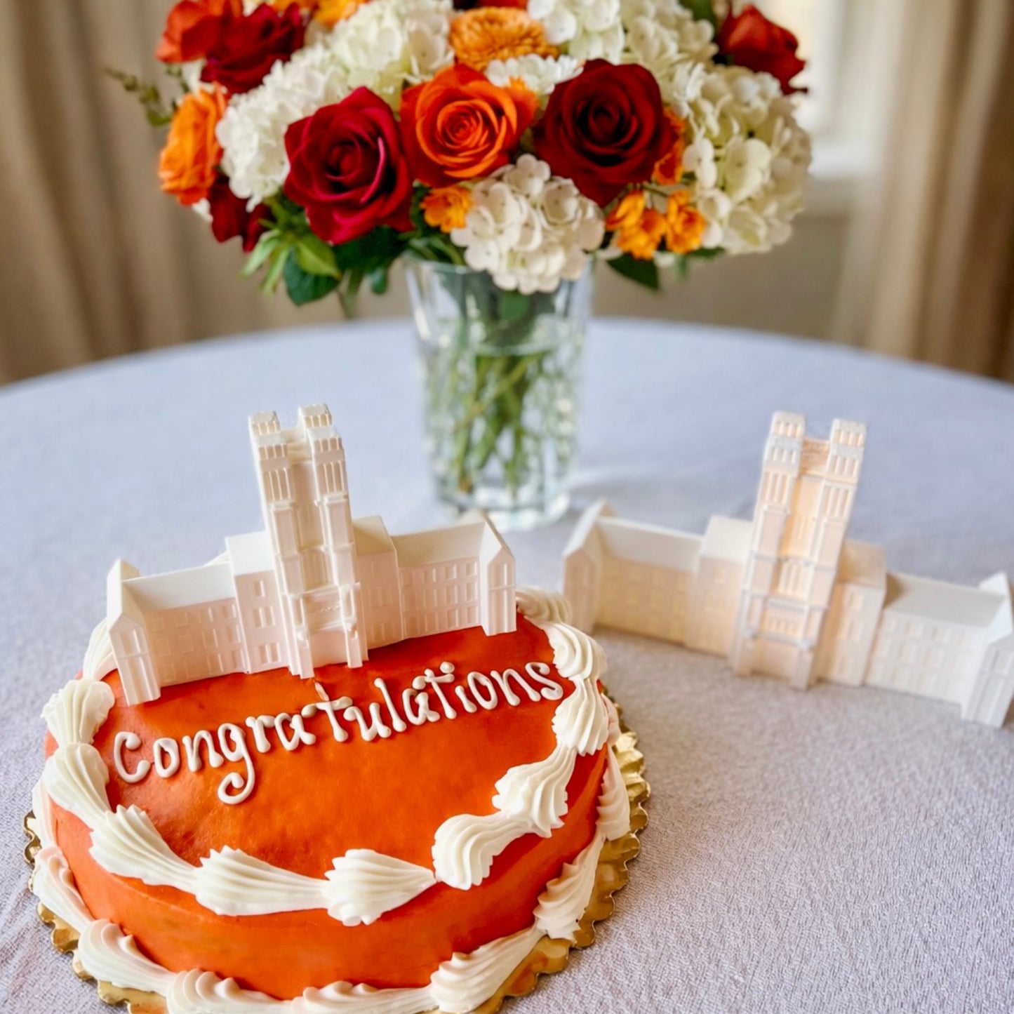 The Virginia Tech cake topper figurines designed as replicas of the Burruss Hall building and shown at a graduation party as a cake topper and as a party centerpiece.