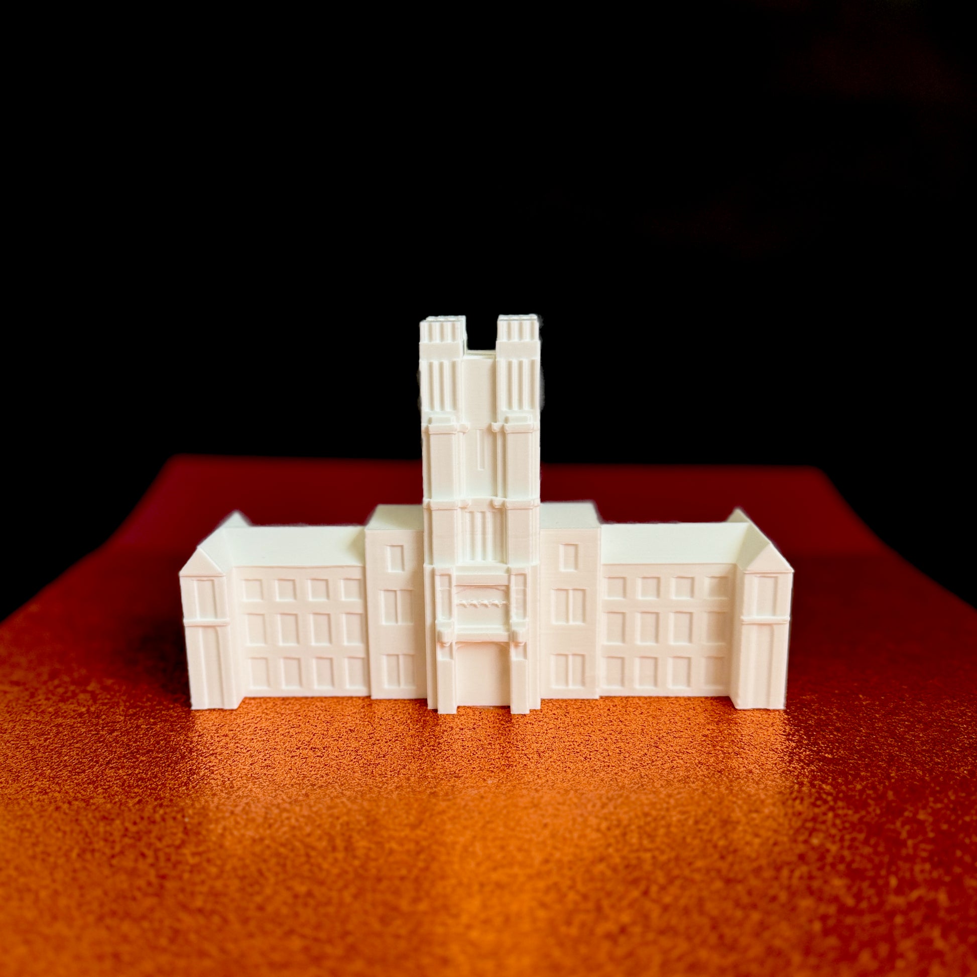 The Virginia Tech cake topper figurine, shown against a background of school colors.