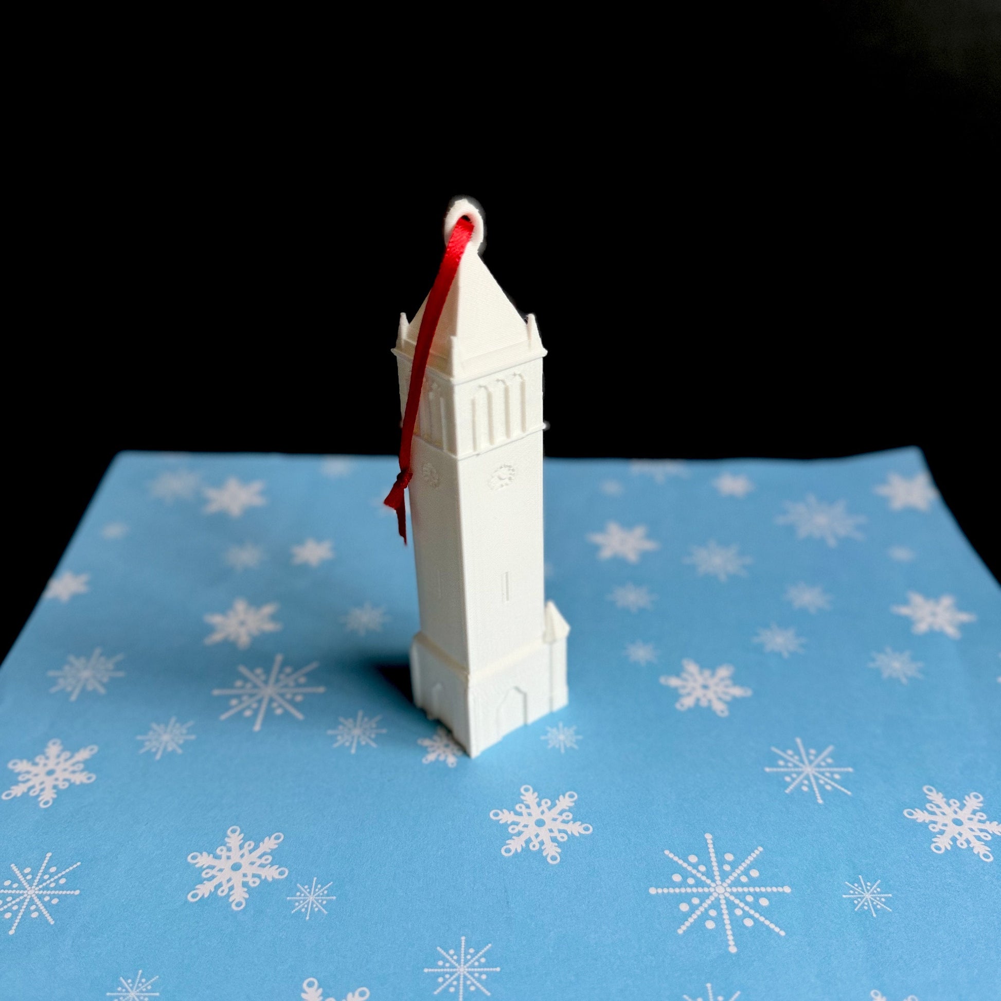 The ISU ornament, shown against a blue holiday background.